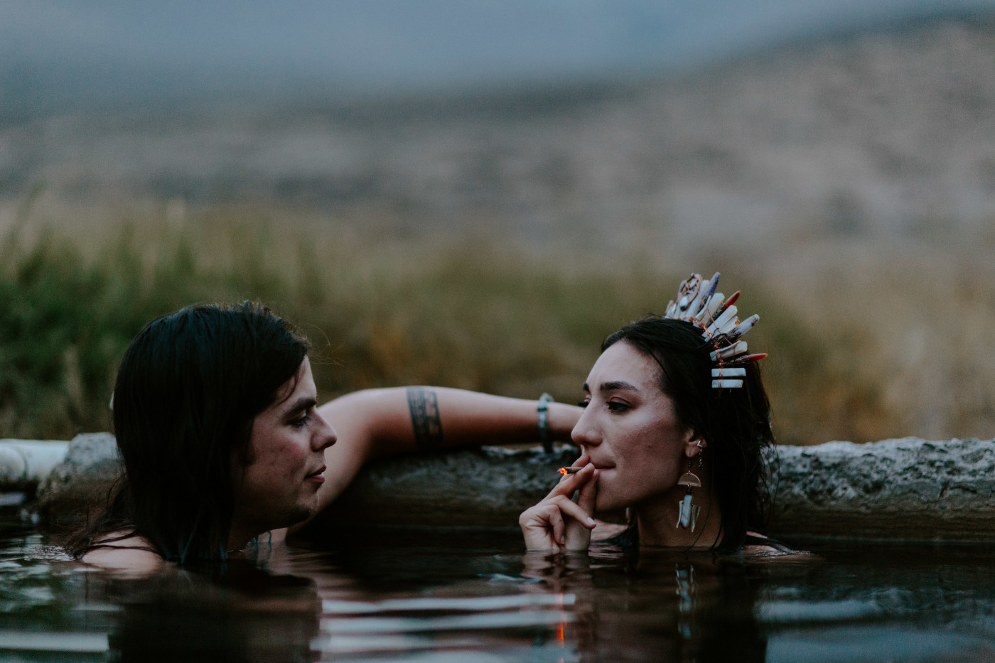 Emerald and Cameron share a joint in the Alvord Desert hot spring at dusk.