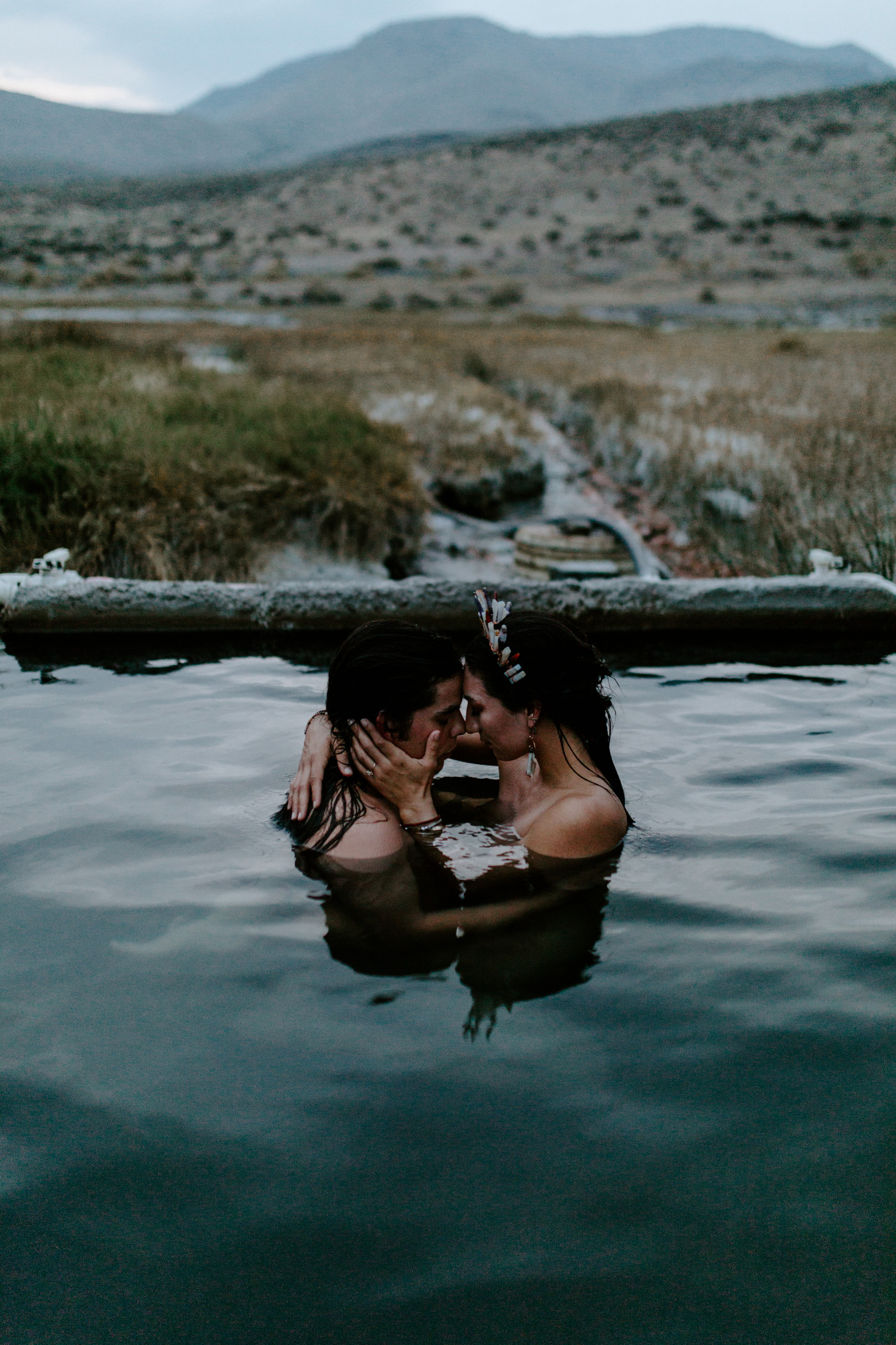 Emerald and Cameron hold each other close in the hot springs at Alvord Desert.