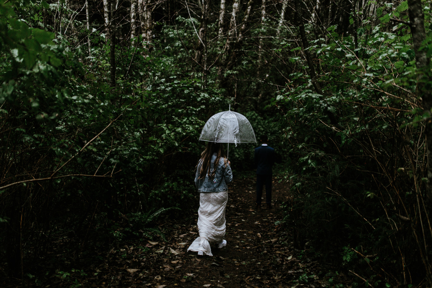 Ariana walks down a path with an umbrella. Elopement photography at Mount Hood by Sienna Plus Josh.