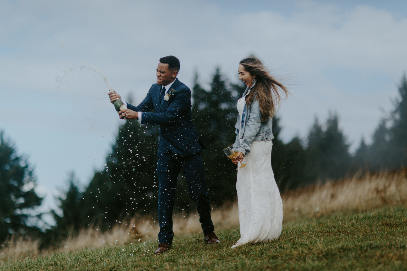 Deandre shakes up the champagne. Elopement photography at Mount Hood by Sienna Plus Josh.