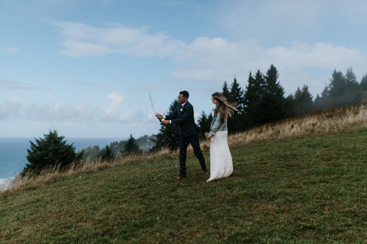 Deandre pops a bottle of champagne. Elopement photography at Mount Hood by Sienna Plus Josh.