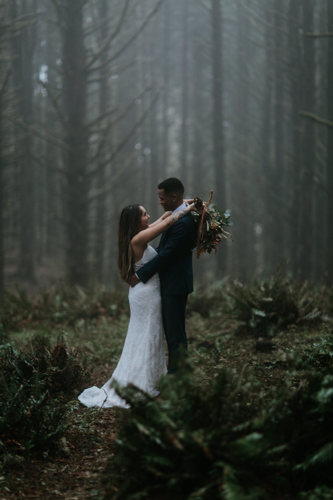 Ariana and Deandre stand together in a foggy forest near the Oregon coast. Elopement photography at Mount Hood by Sienna Plus Josh.