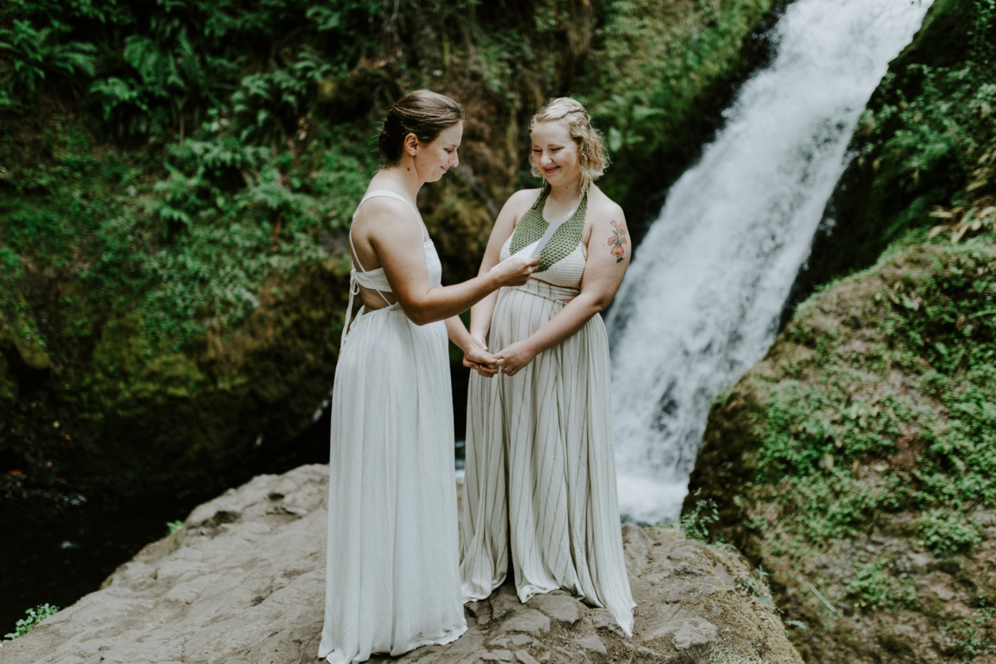 Kate and Audrey stand in front of the waterfall at Bridal Veil Falls. Elopement wedding photography at Bridal Veil Falls by Sienna Plus Josh.