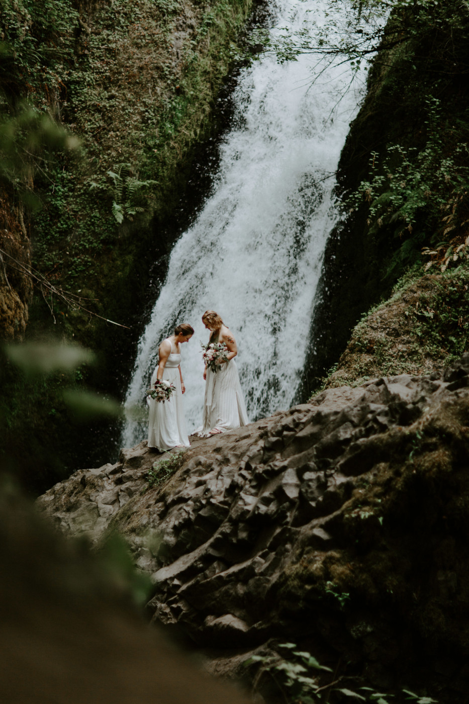 Audrey and Kate admire their dresses in front of Bridal Veil Falls. Elopement wedding photography at Bridal Veil Falls by Sienna Plus Josh.
