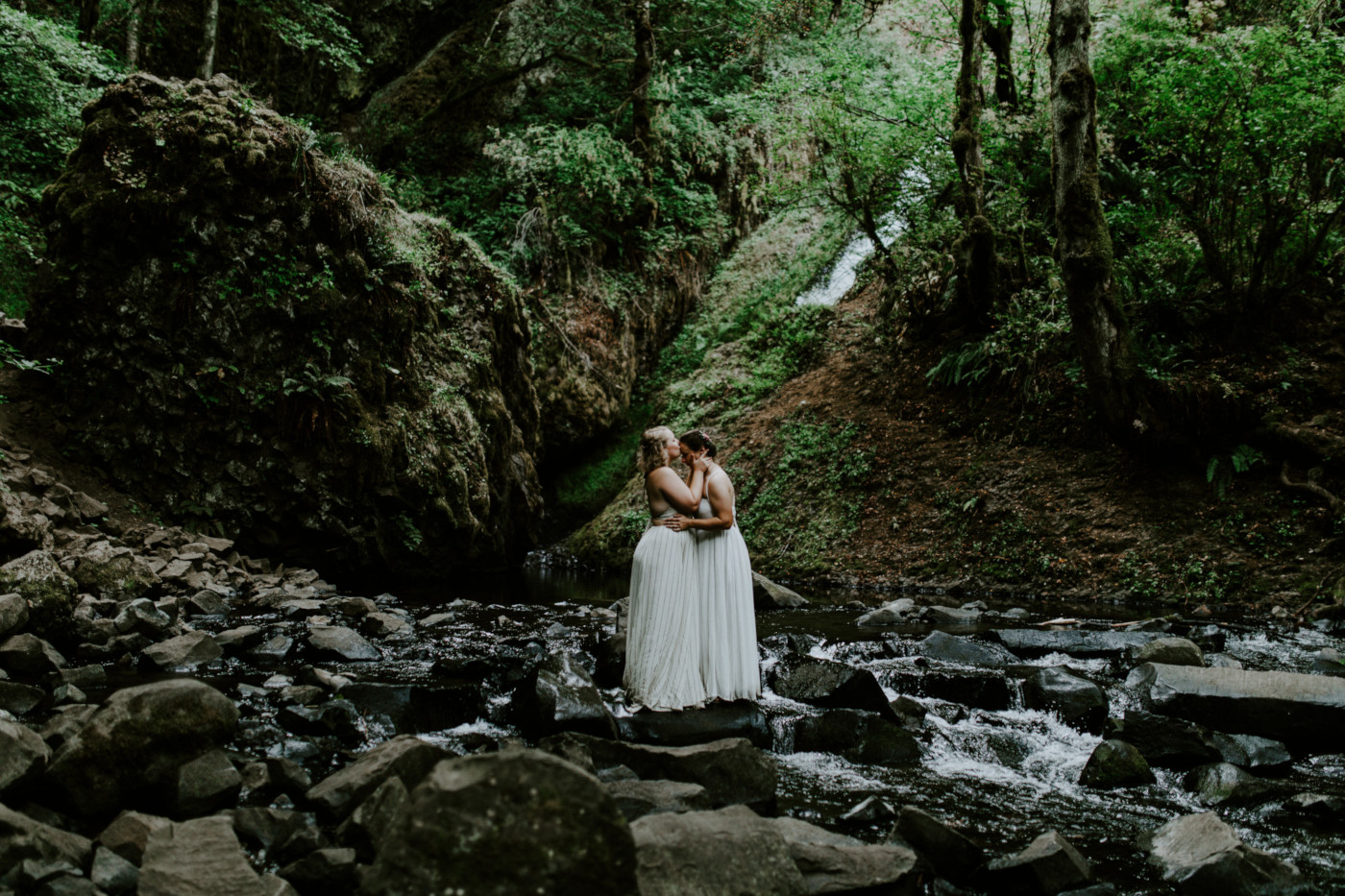 Kate and Audrey stand along the stream. Elopement wedding photography at Bridal Veil Falls by Sienna Plus Josh.