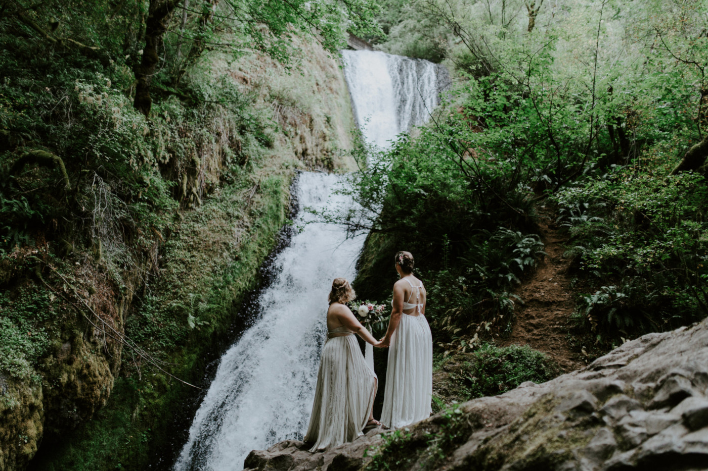 Audrey and Kate look at Bridal Veil Falls. Elopement wedding photography at Bridal Veil Falls by Sienna Plus Josh.