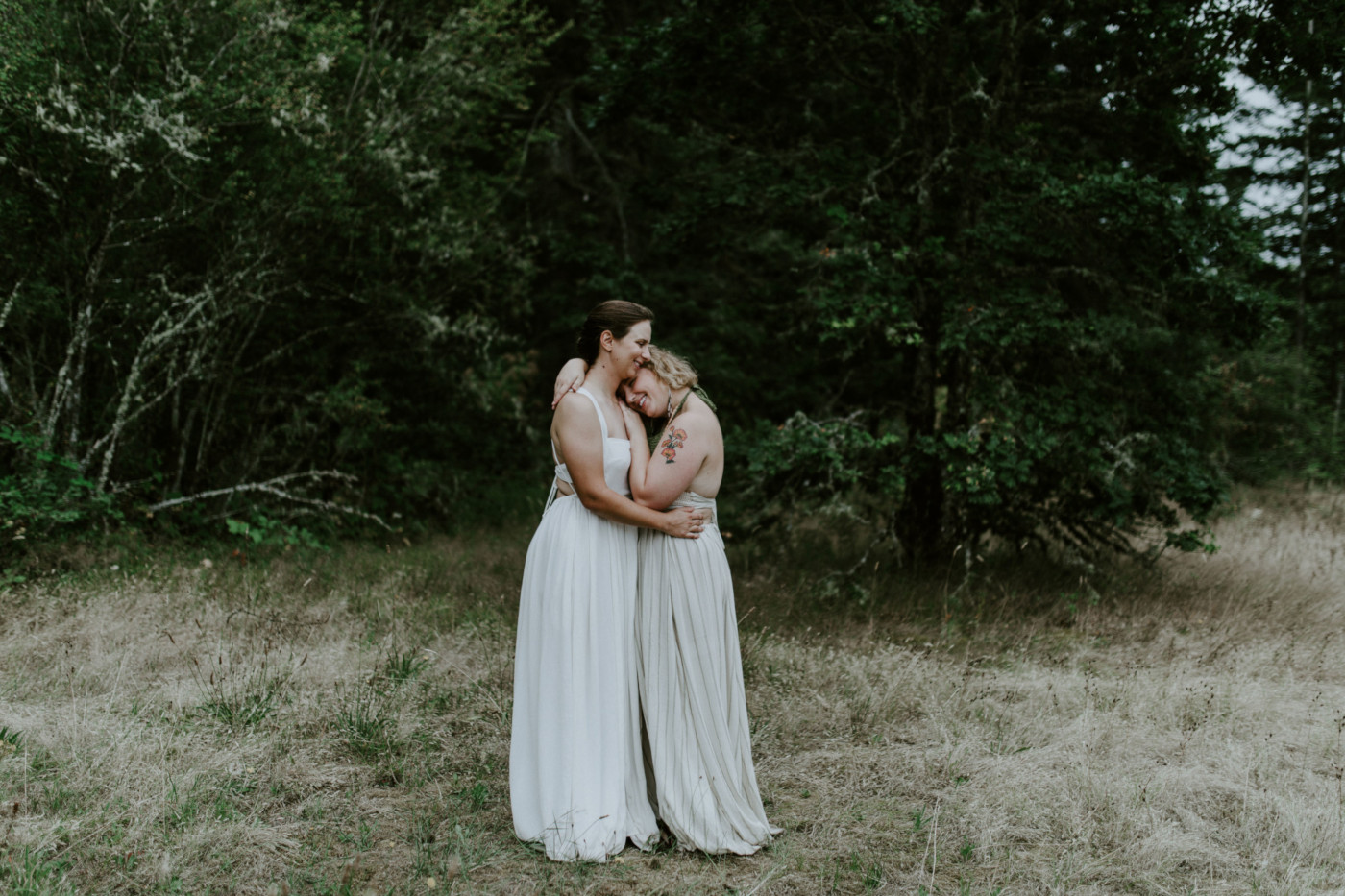 Kate and Audrey hug in a field. Elopement wedding photography at Bridal Veil Falls by Sienna Plus Josh.