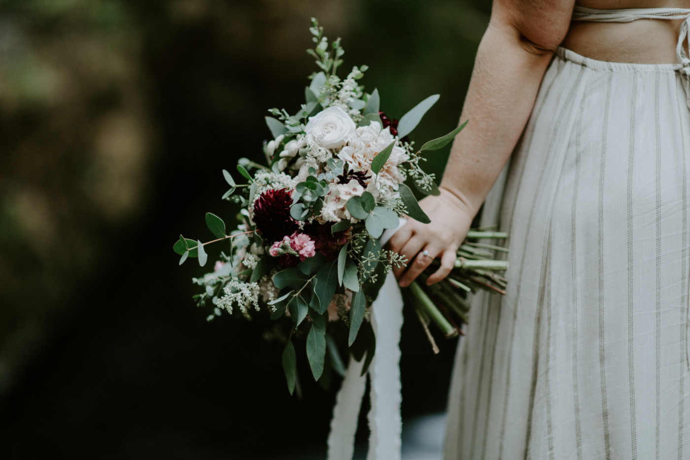 Audrey's bouquet hangs by her side. Elopement wedding photography at Bridal Veil Falls by Sienna Plus Josh.
