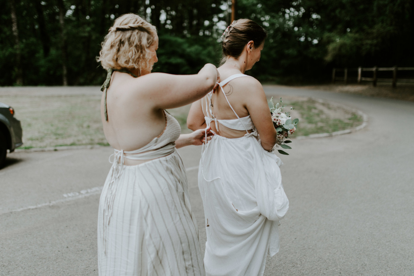 Kate helps Audrey fix up her dress. Elopement wedding photography at Bridal Veil Falls by Sienna Plus Josh.