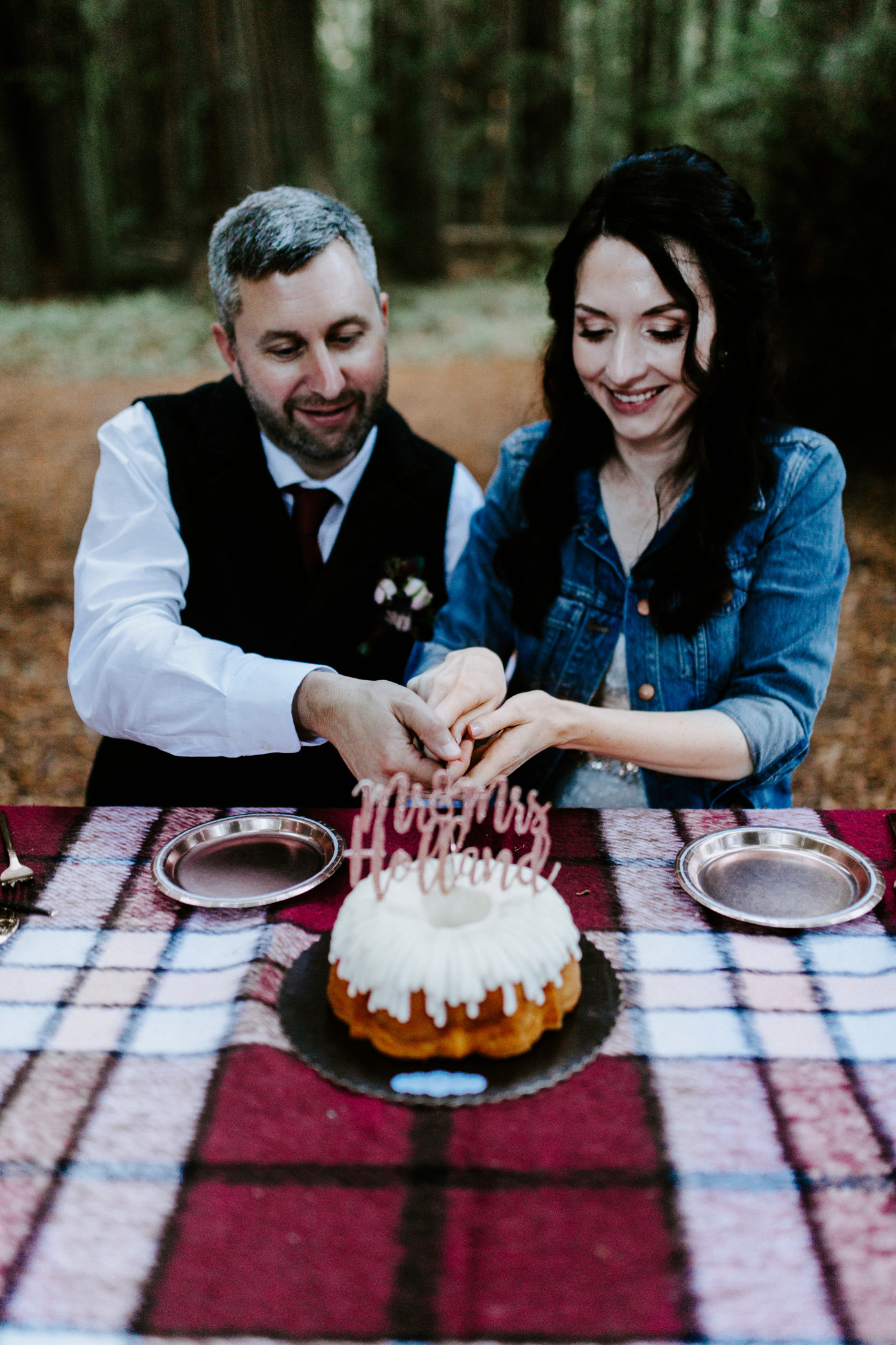 Tim and Hannah cut their wedding cake at their elopement picnic in the California Redwoods.