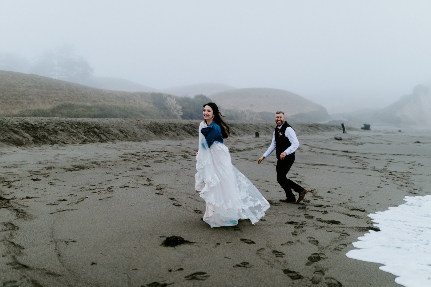 Hannah and Tim run away from the ocean waves.