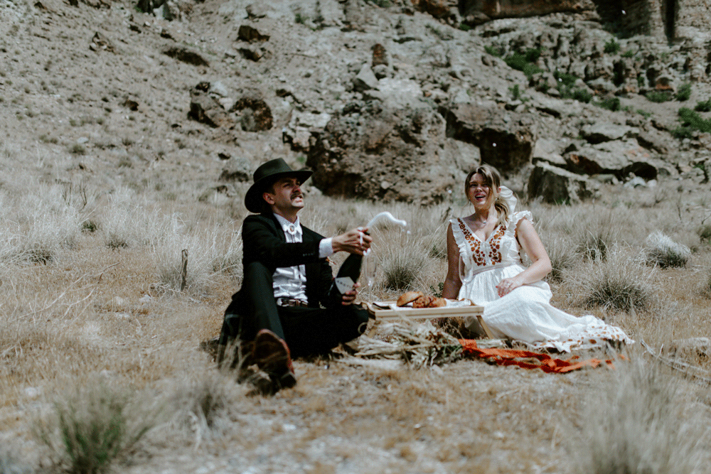 Animated gif of Emily and Greyson pop open a bottle of champagne. Elopement photography in the Central Oregon desert by Sienna Plus Josh.