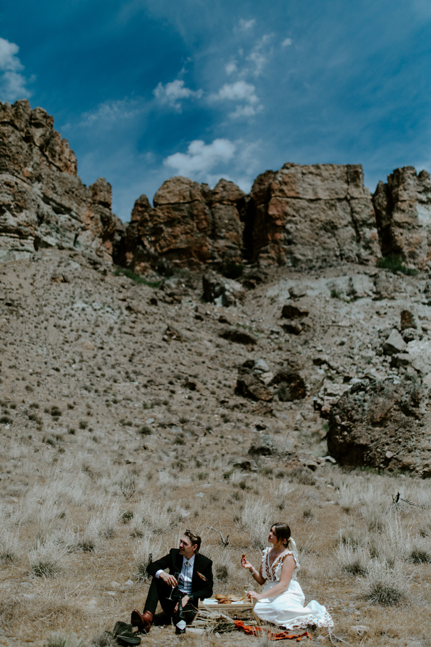 Greyson and Emily look out at the scenery. Elopement photography in the Central Oregon desert by Sienna Plus Josh.