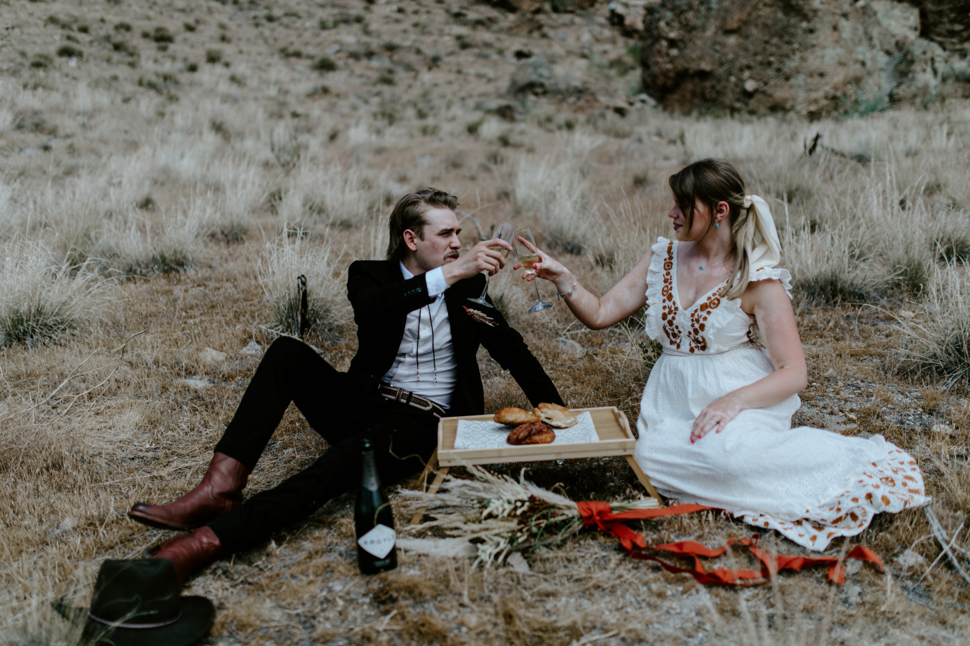 Greyson and Emily cheers. Elopement photography in the Central Oregon desert by Sienna Plus Josh.