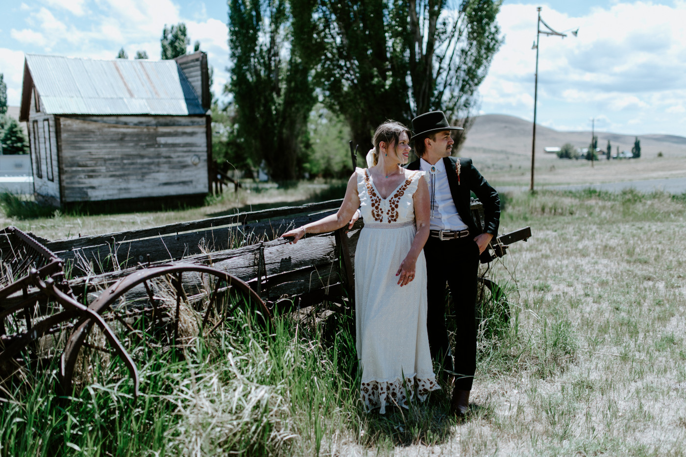 Greyson and Emily stand together in a field. Elopement photography in the Central Oregon desert by Sienna Plus Josh.