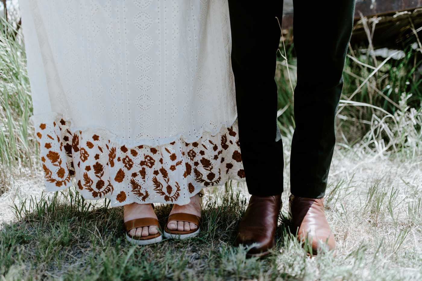Emily and Greyson stand together to show their shoes. Elopement photography in the Central Oregon desert by Sienna Plus Josh.