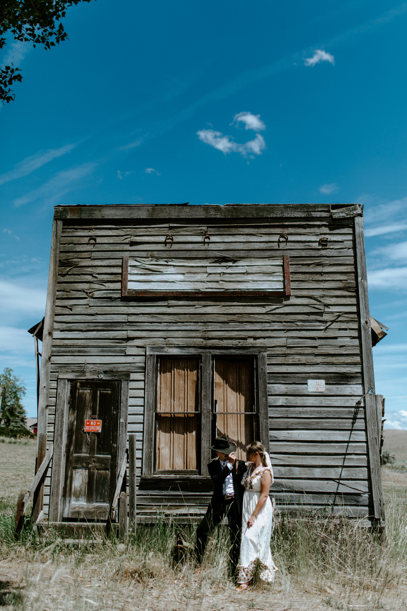 Emily and Greyson stand in front of an old western building. Elopement photography in the Central Oregon desert by Sienna Plus Josh.