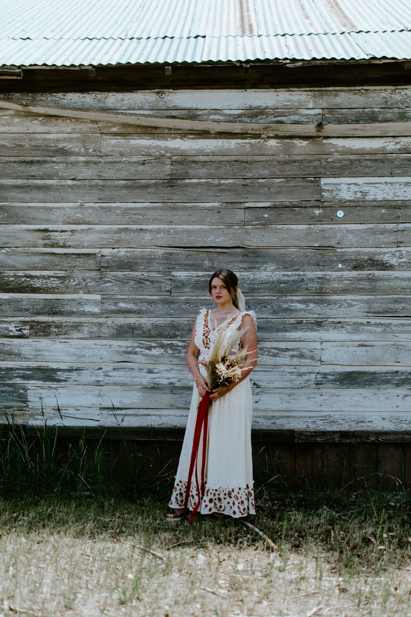Emily stands with her flowers. Elopement photography in the Central Oregon desert by Sienna Plus Josh.