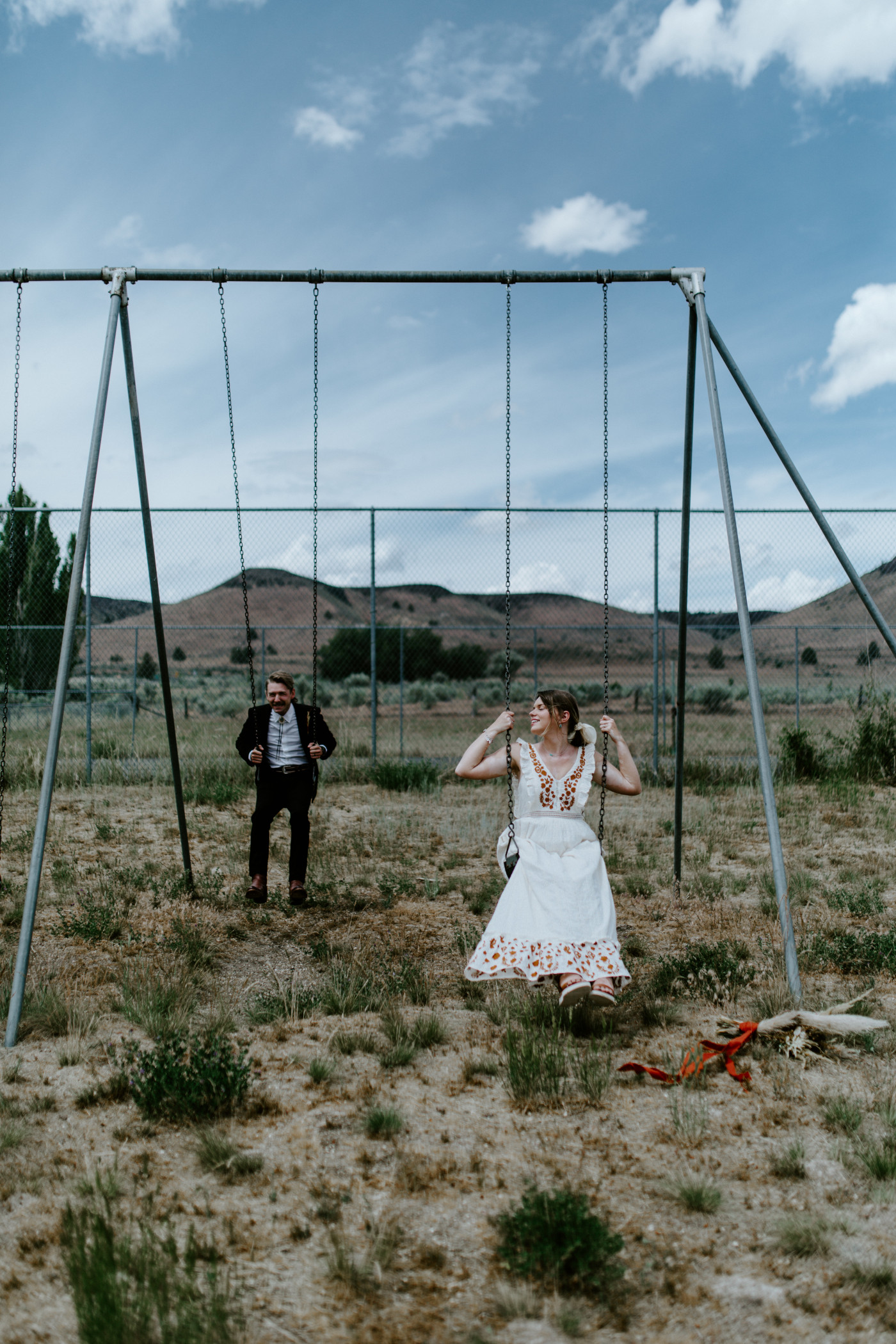 Emily and Greyson on a swing set. Elopement photography in the Central Oregon desert by Sienna Plus Josh.