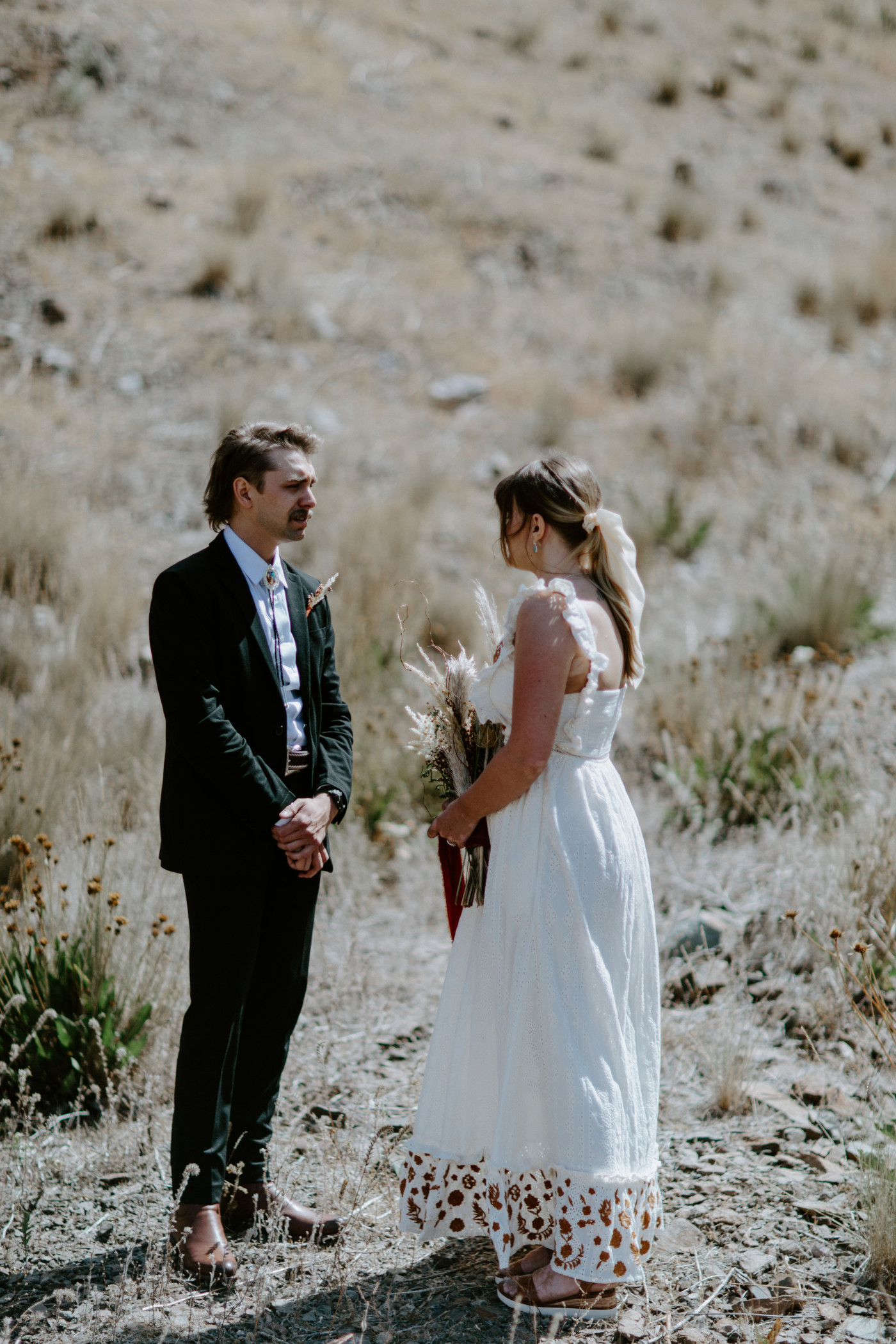 Emily and Greyson stand together. Elopement photography in the Central Oregon desert by Sienna Plus Josh.