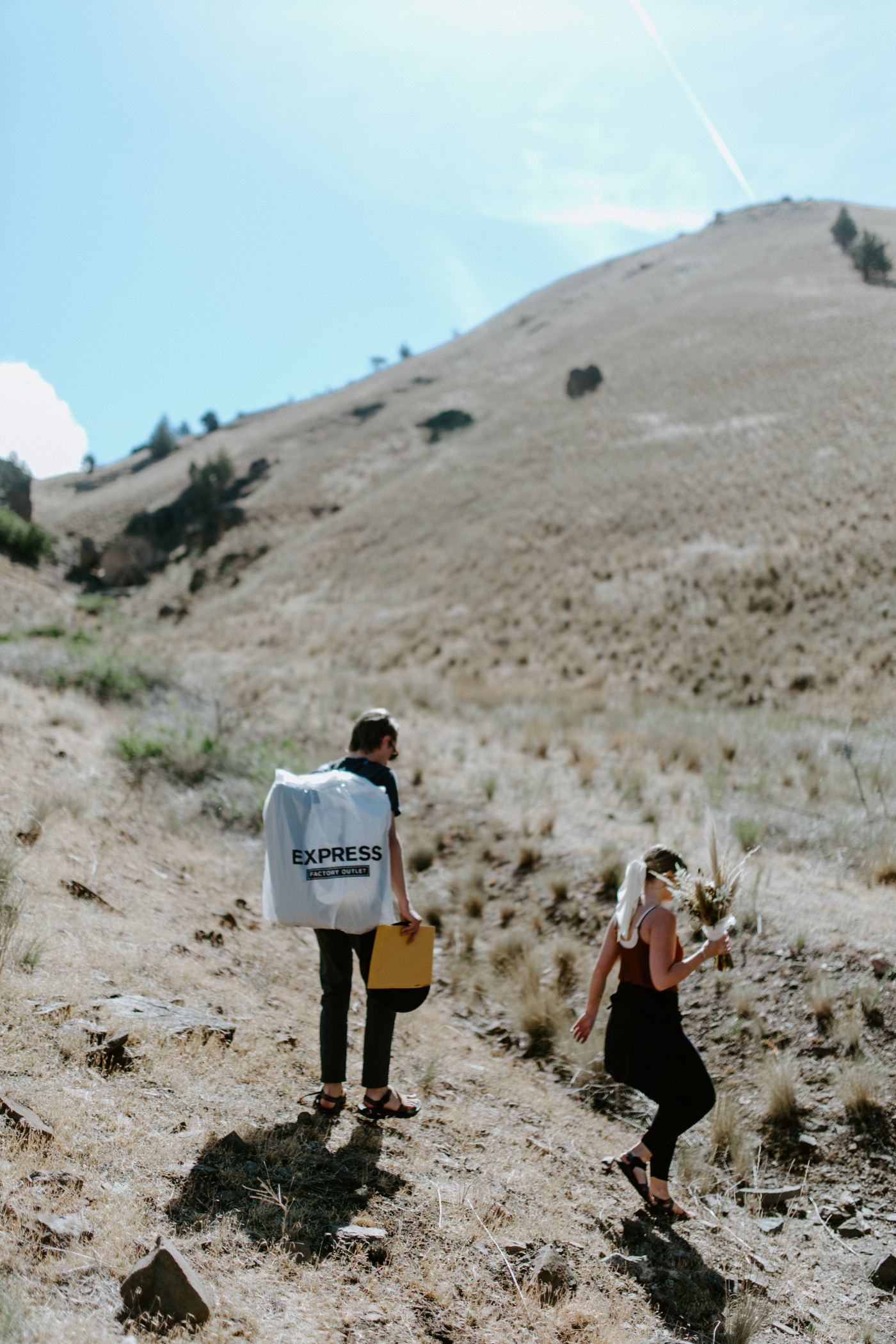 Greyson and Emily make their way through the foothills. Elopement photography in the Central Oregon desert by Sienna Plus Josh.