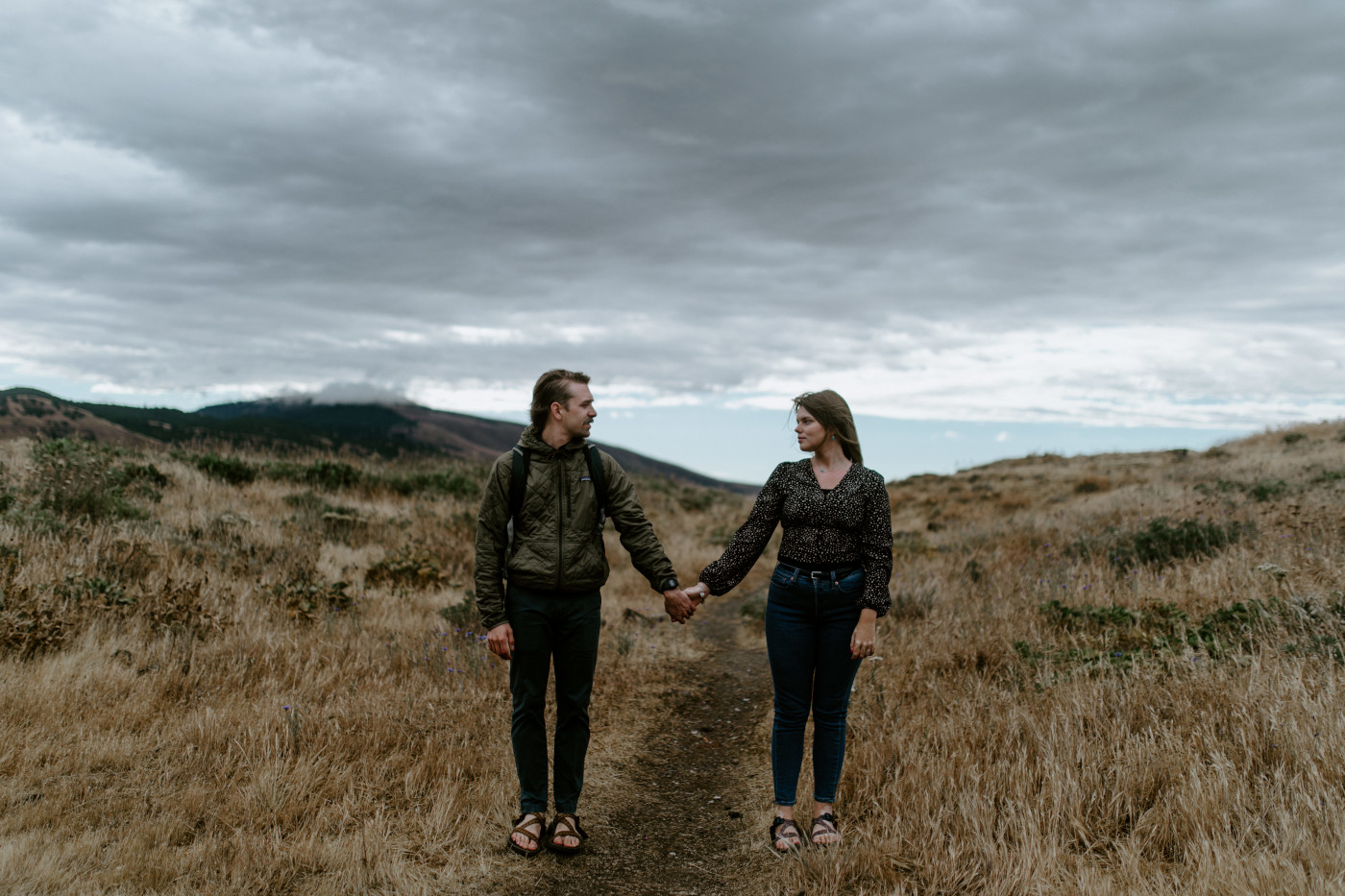 Greyson and Emily stand hand in hand. Elopement photography in the Central Oregon desert by Sienna Plus Josh.