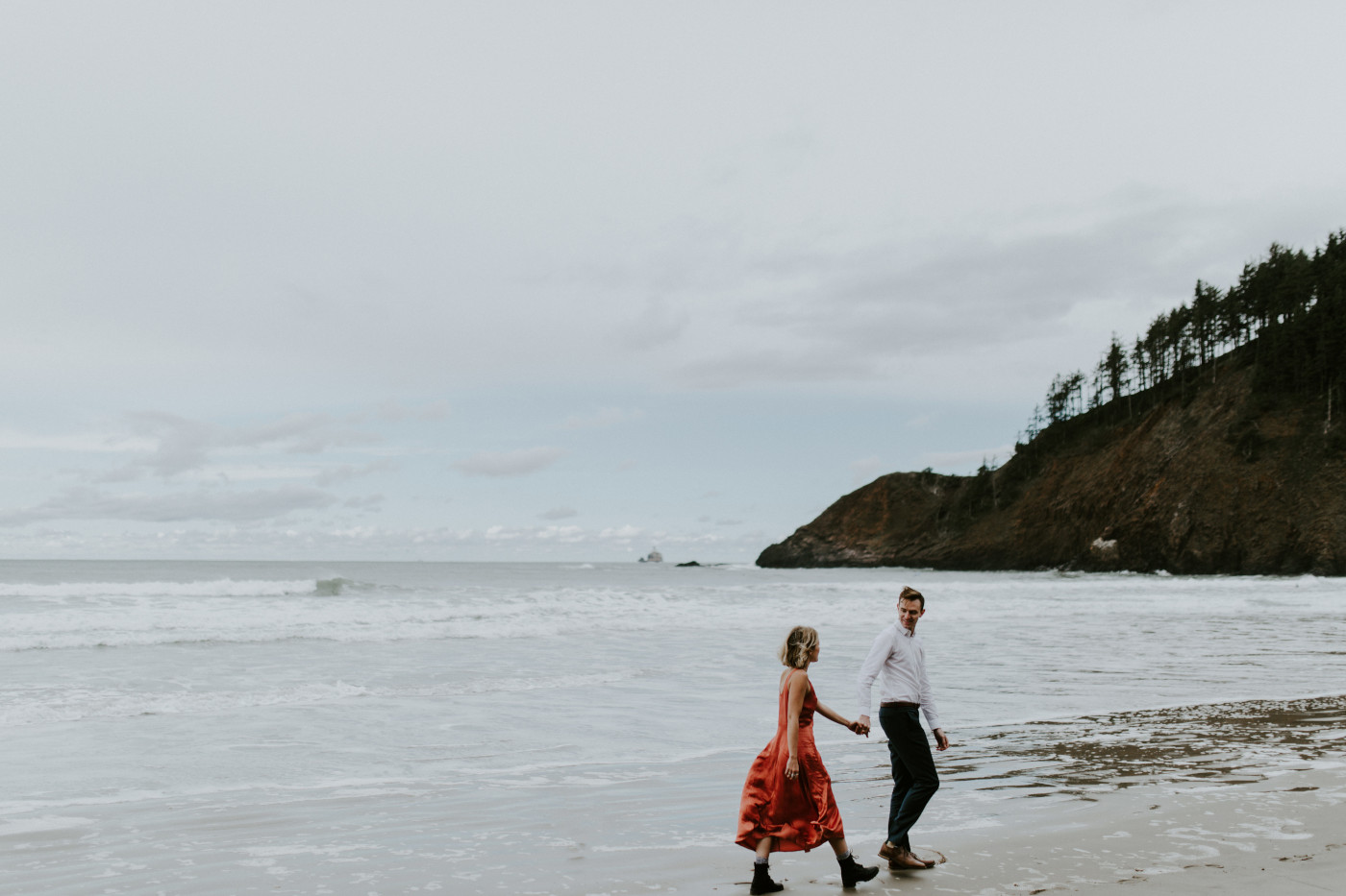 Billy and Chelsey walk along Cannon Beach. Elopement wedding photography at Cannon Beach by Sienna Plus Josh.