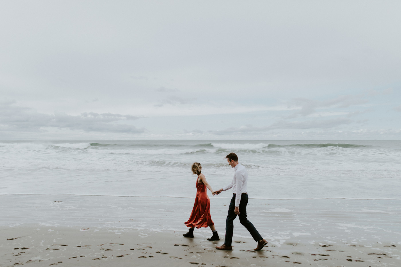 Chelsey and Billy walk on the beach. Elopement wedding photography at Cannon Beach by Sienna Plus Josh.