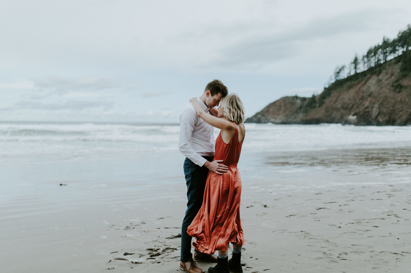 Billy and Chelsey stand with their foreheads together on the beach. Elopement wedding photography at Cannon Beach by Sienna Plus Josh.