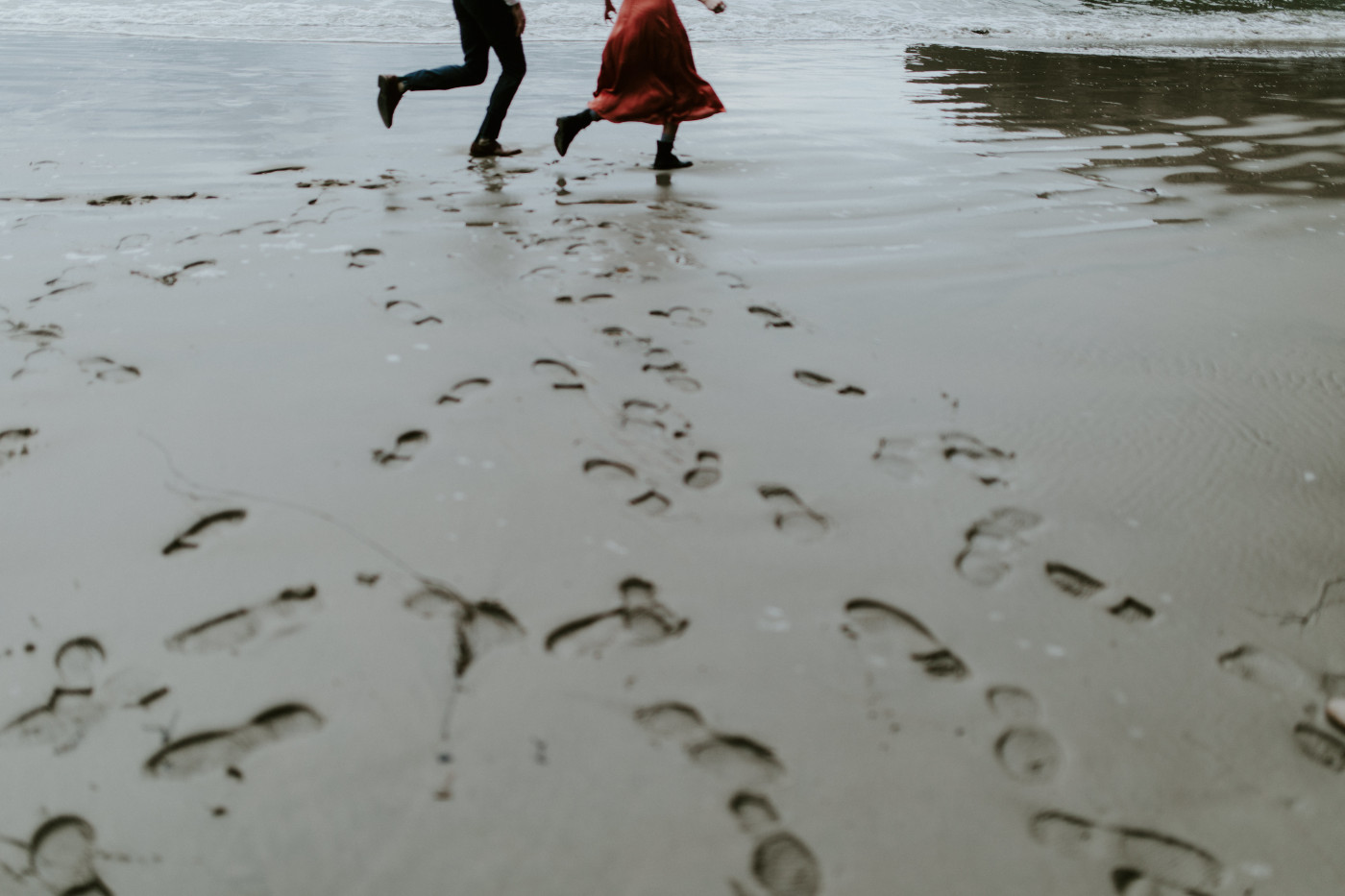 Chelsey and Billy's footprints on the sand as they run together'. Elopement wedding photography at Cannon Beach by Sienna Plus Josh.