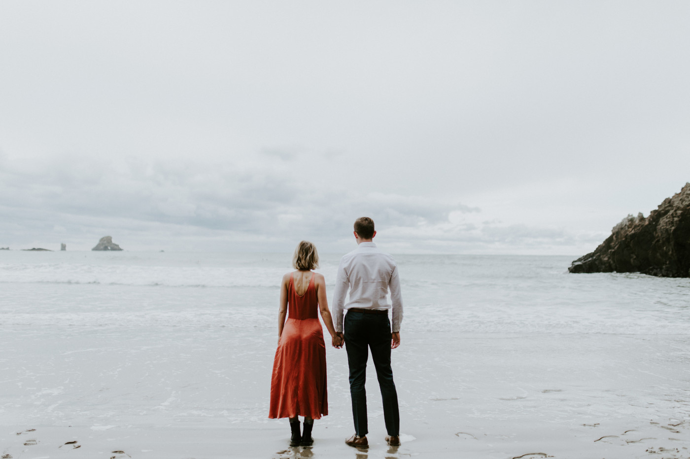 Billy and Chelsey hold hands, standing side by side. Elopement wedding photography at Cannon Beach by Sienna Plus Josh.