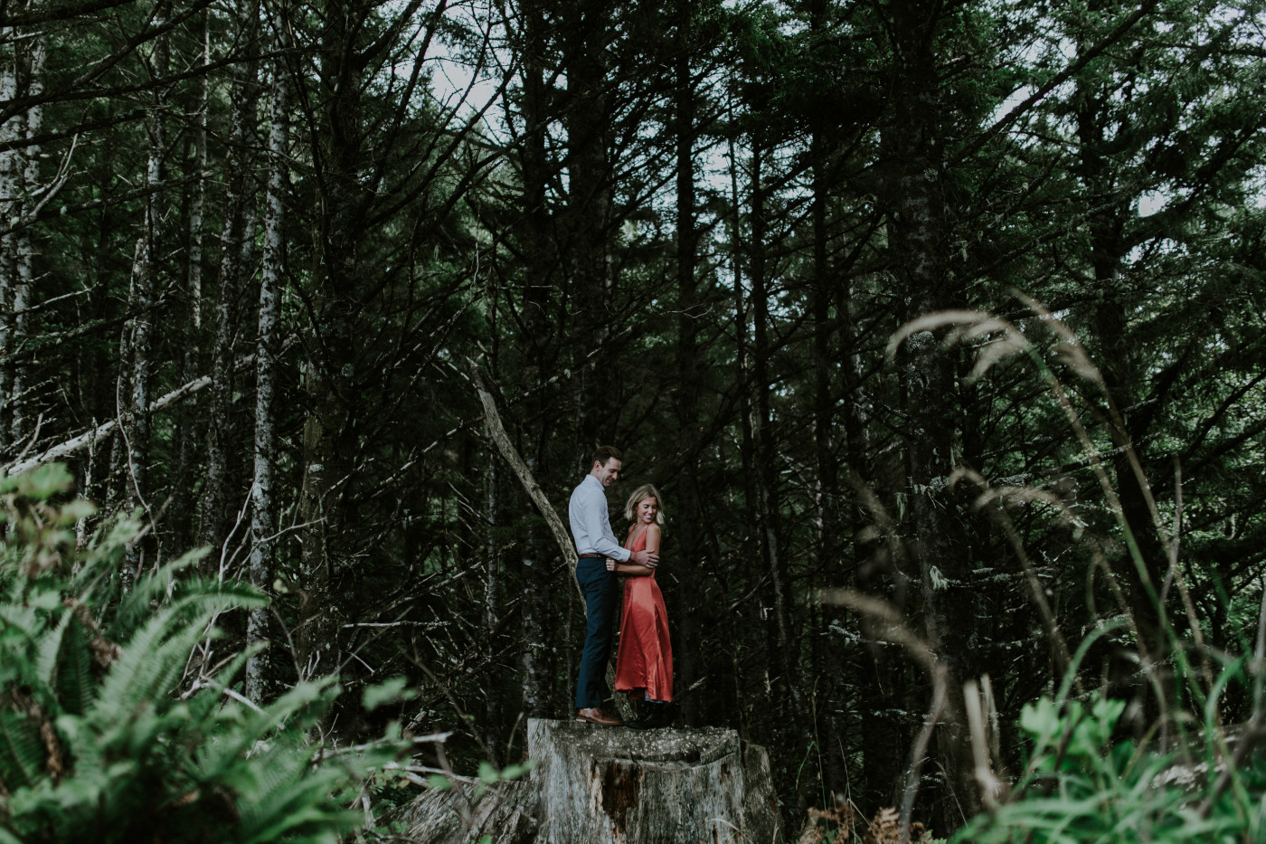 Billy and Chelsey stand a large tree trunk at Cannon Beach. Elopement wedding photography at Cannon Beach by Sienna Plus Josh.