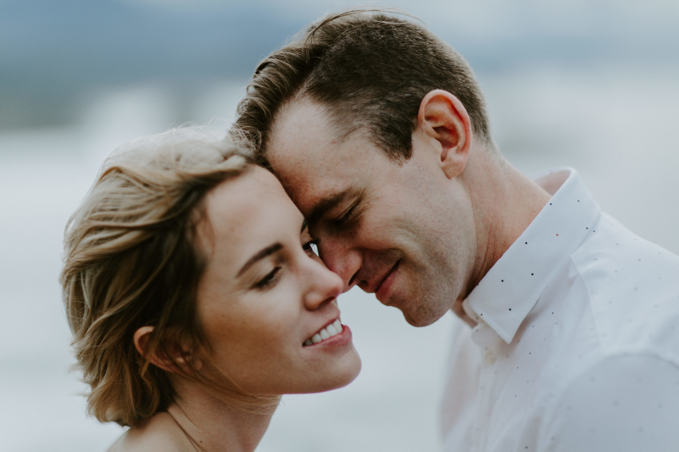 Billy goes to kiss Chelsey on the cheek. Elopement wedding photography at Cannon Beach by Sienna Plus Josh.