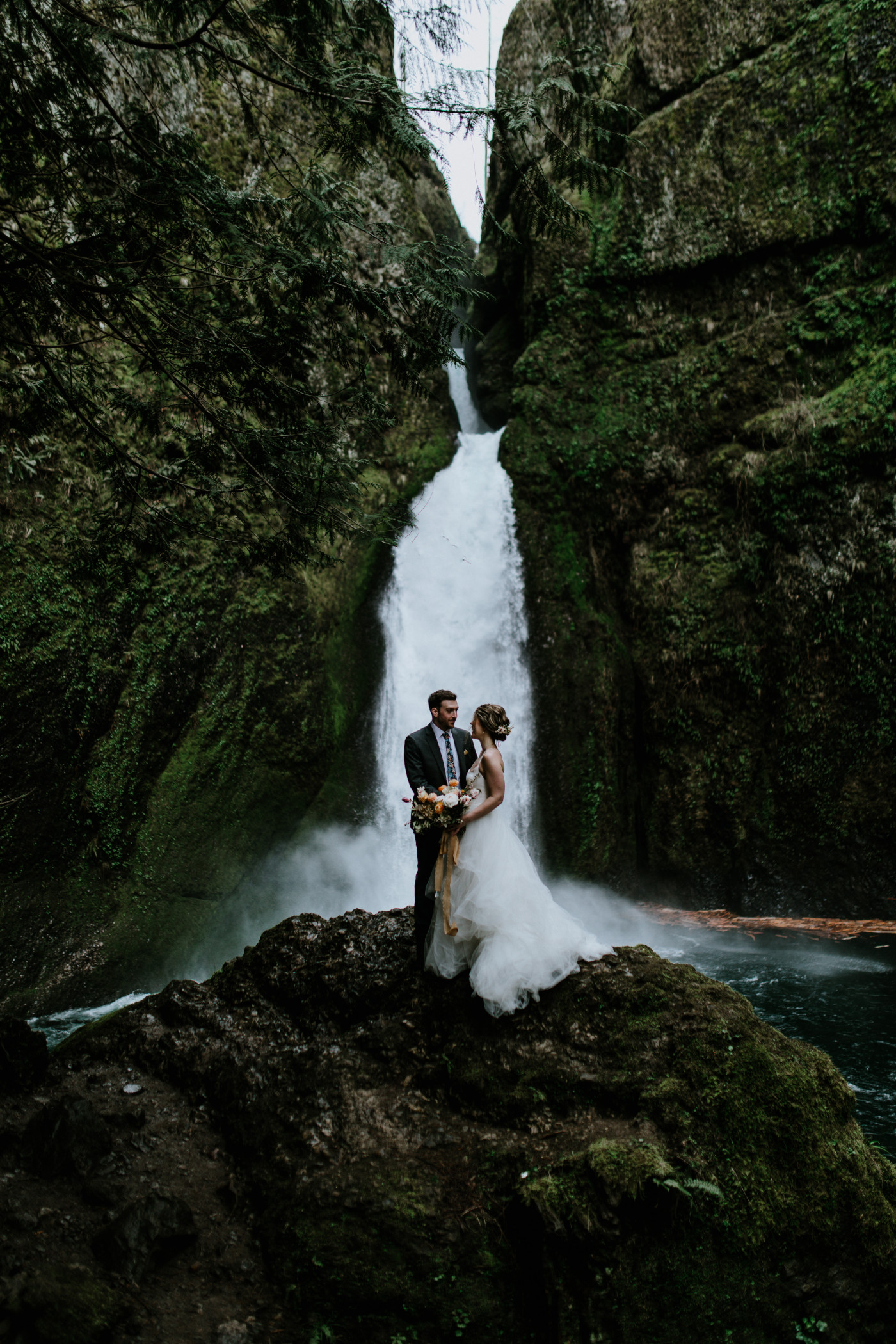 Allison and Lennie stand in front of a waterfall. Elopement photography at Columbia River Gorge by Sienna Plus Josh.