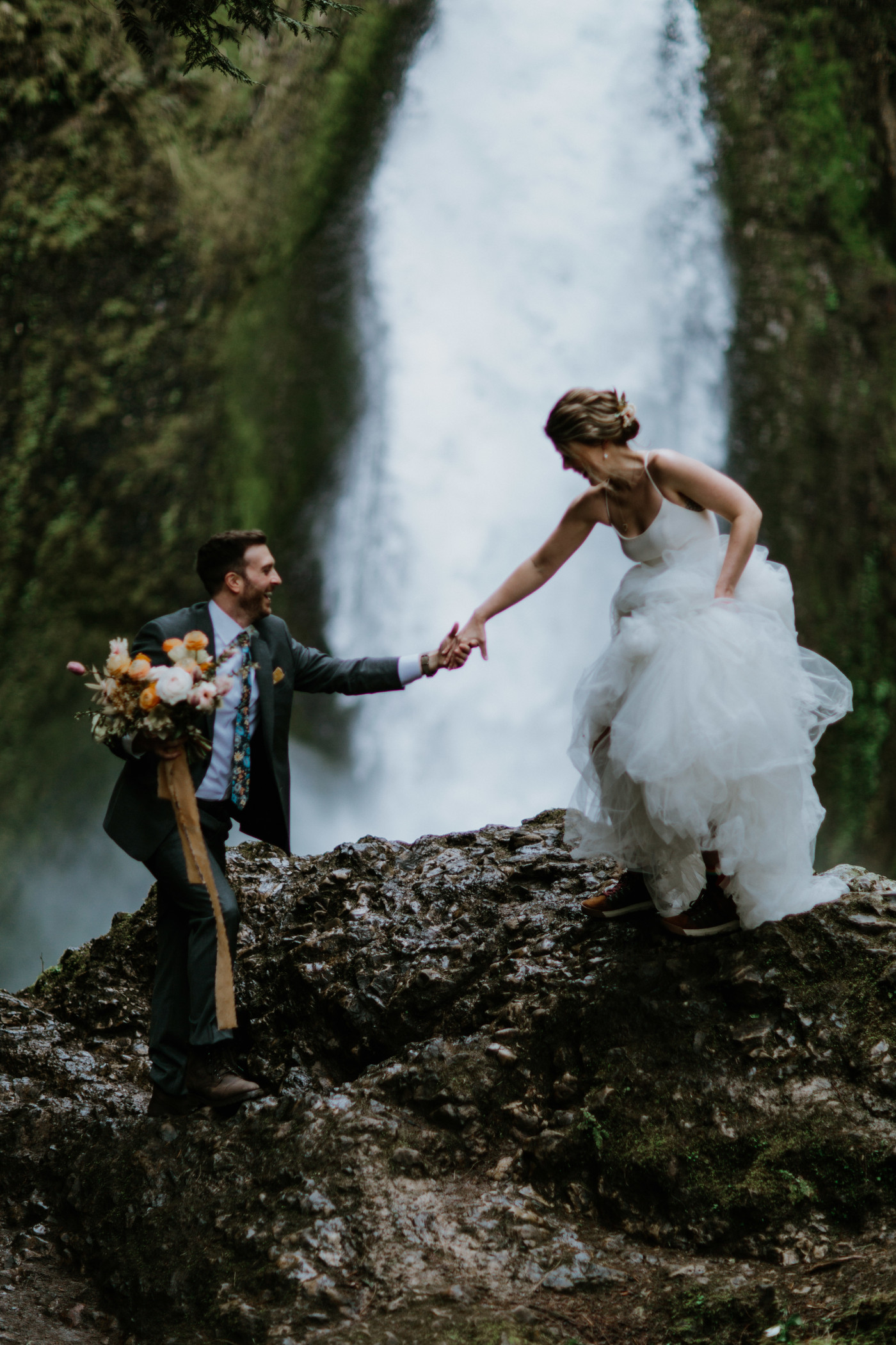 Lennie and Allison make their way down a rock. Elopement photography at Columbia River Gorge by Sienna Plus Josh.
