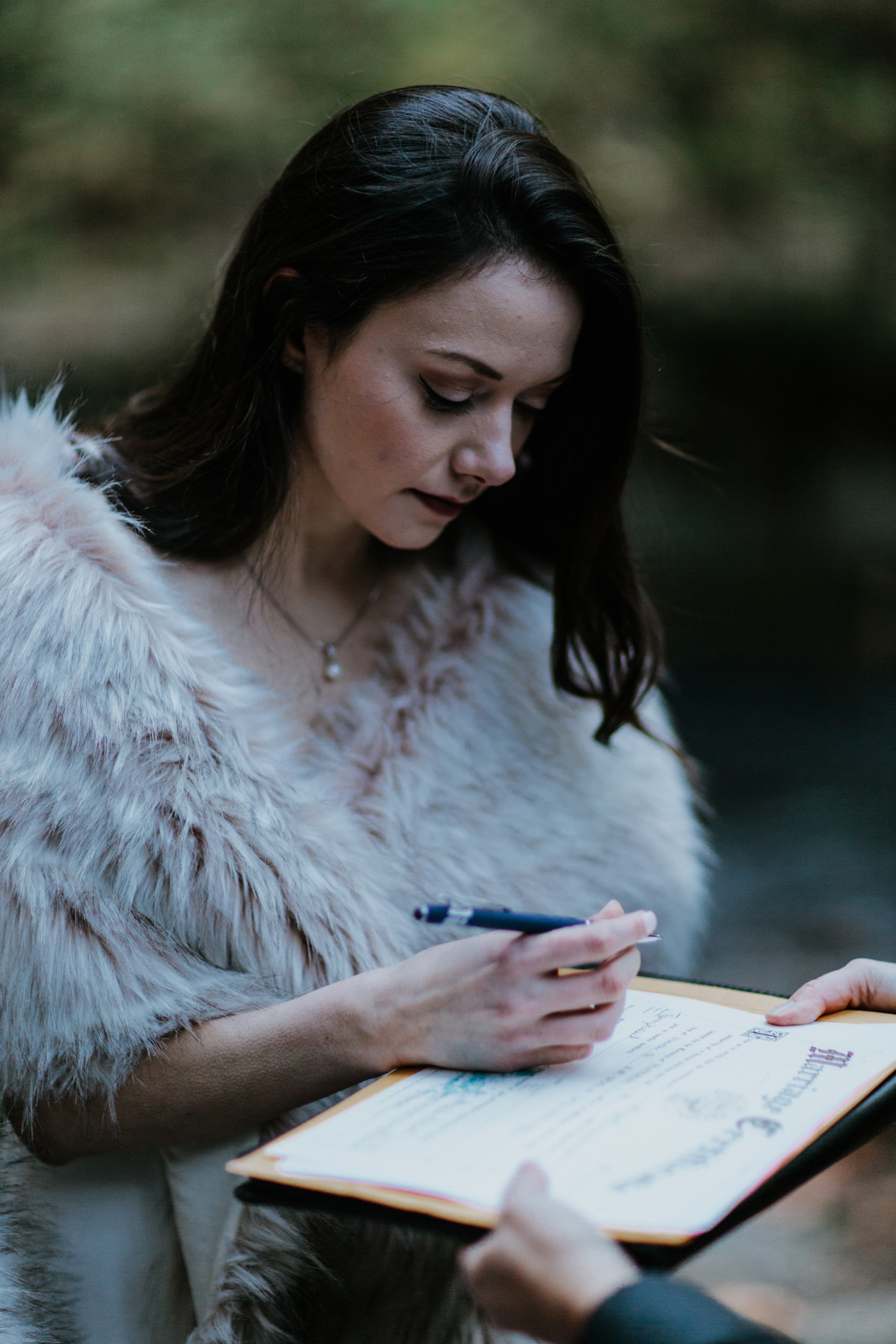Hayley signs paperwork. Elopement photography at the Columbia River Gorge by Sienna Plus Josh.
