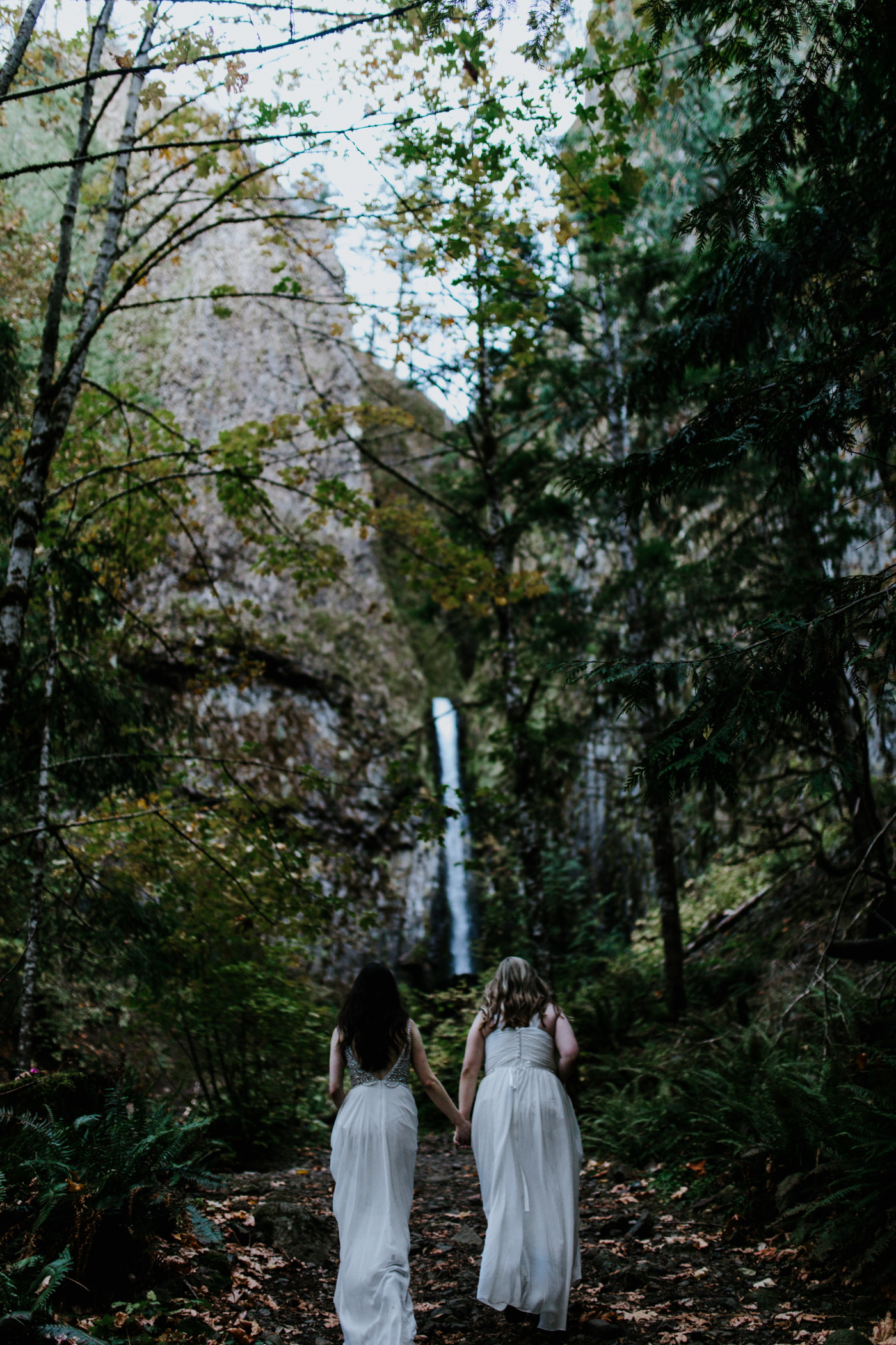 Hayley and Tiffany make their way toward the waterfall. Elopement photography at the Columbia River Gorge by Sienna Plus Josh.