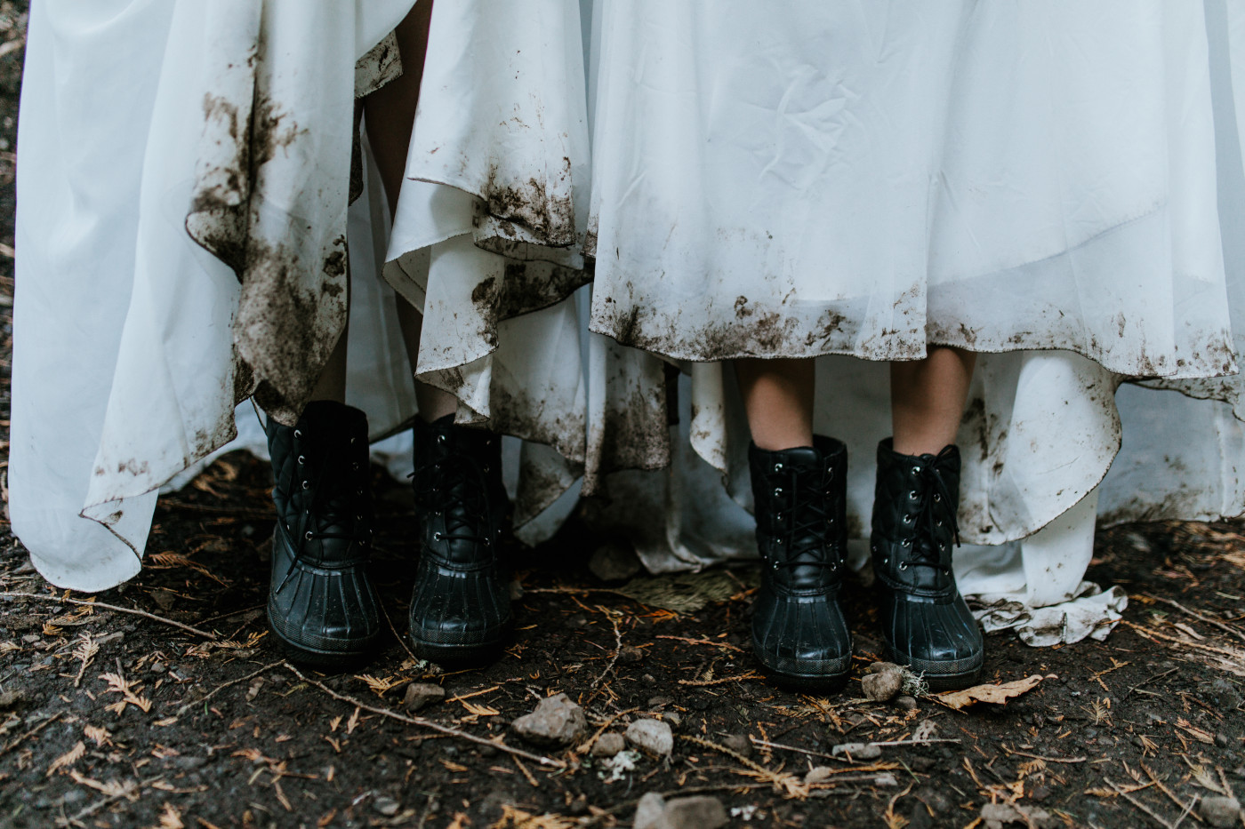 Hayley and Tiffany show off their muddy boots from hiking. Elopement photography at the Columbia River Gorge by Sienna Plus Josh.