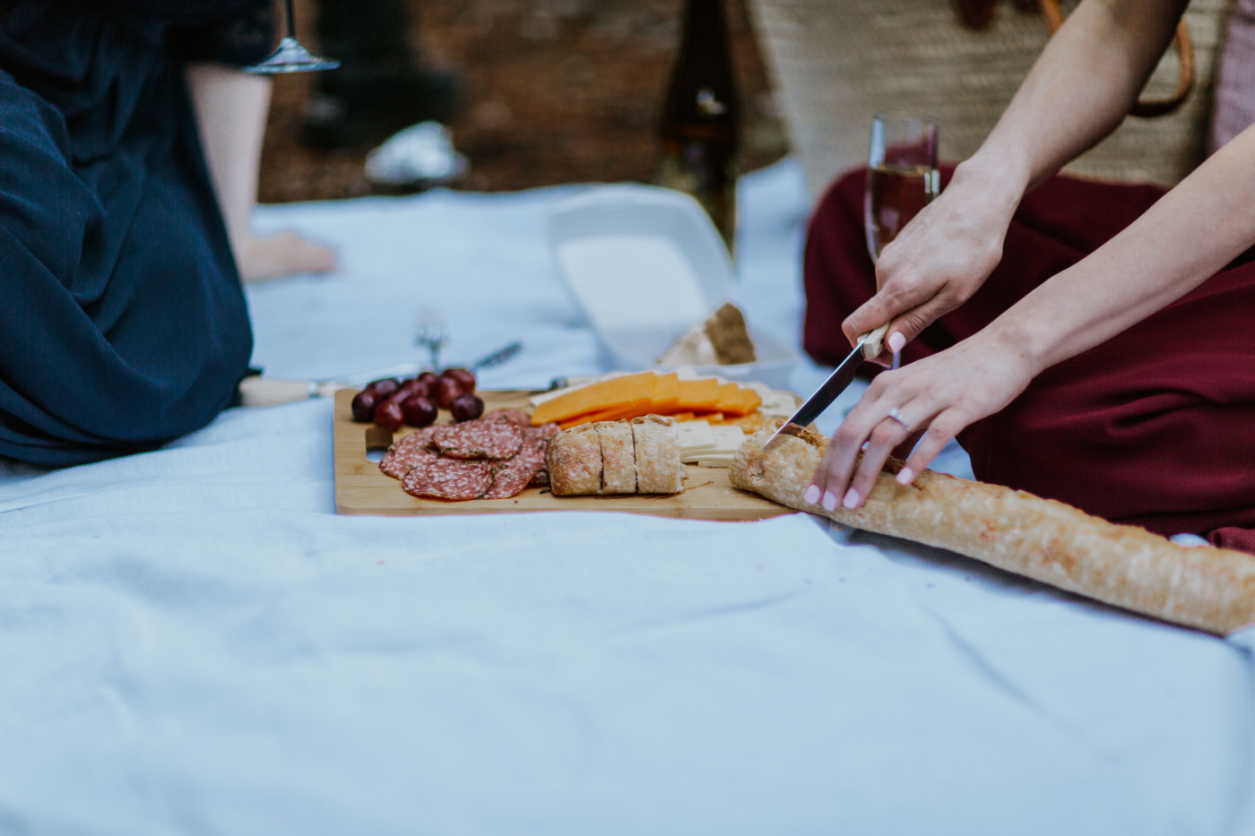 Tiffany and Hayley cut bread. Elopement photography at the Columbia River Gorge by Sienna Plus Josh.