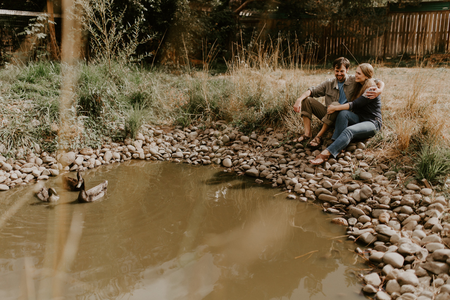Dan and Hannah sit next to a pond in Corvallis Oregon. Intimate wedding photography in Corvallis Oregon by Sienna Plus Josh.