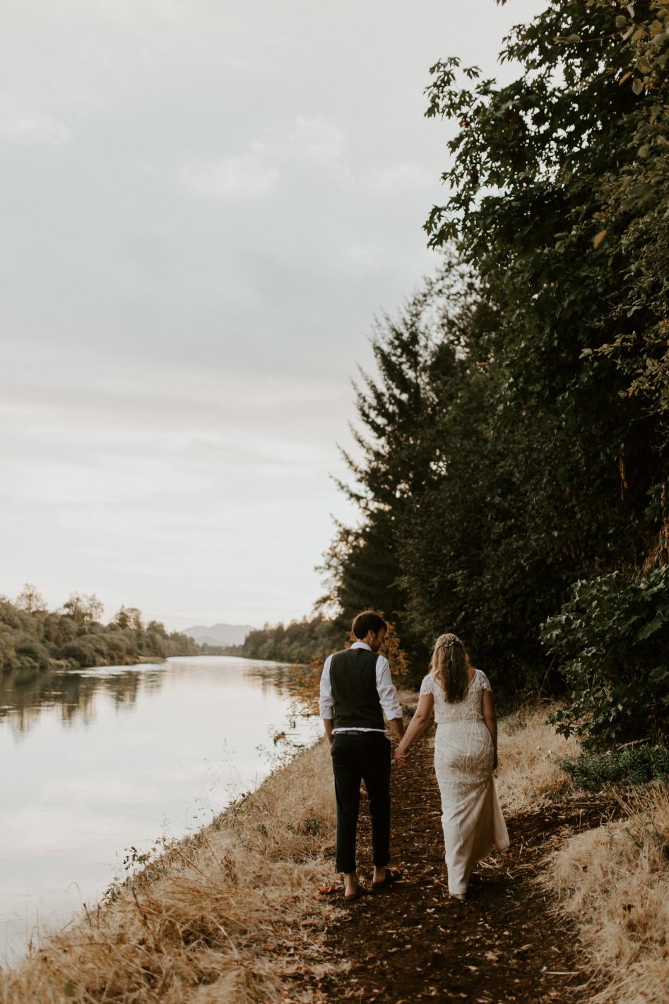 Hannah and Dan walk along the Willamette river in Corvallis, Oregon. Intimate wedding photography in Corvallis Oregon by Sienna Plus Josh.