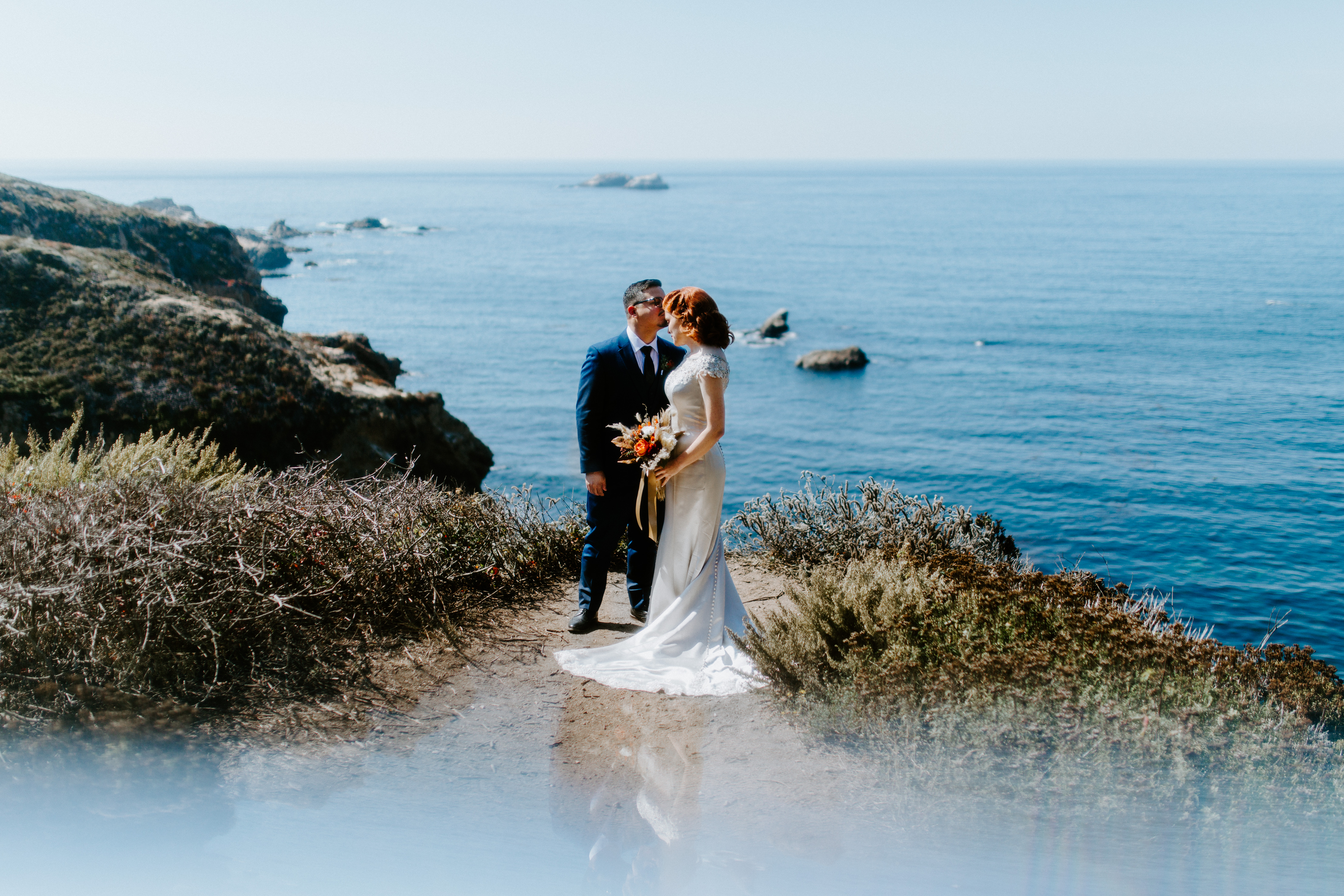 A couple stands at a viewpoint along the Big Sur coastline in Big Sur, California.