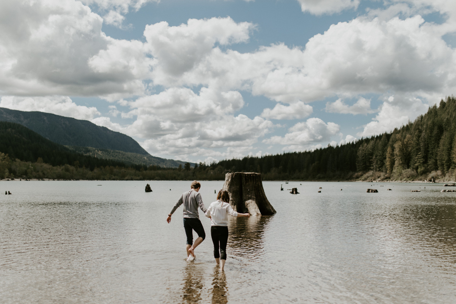 Adam and Janelle wade into Rattlesnake Lake, WA. Adventure engagement session at Rattlesnake Lake, Washington by Sienna Plus Josh.