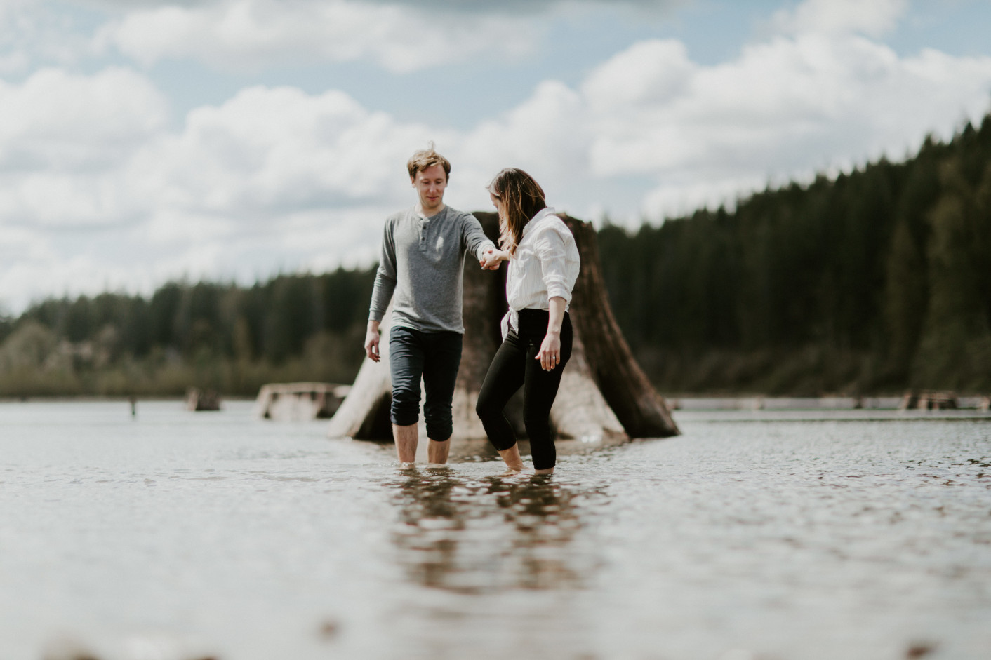 Janelle and Adam wade in the water at Rattlesnake Lake. Adventure engagement session at Rattlesnake Lake, Washington by Sienna Plus Josh.