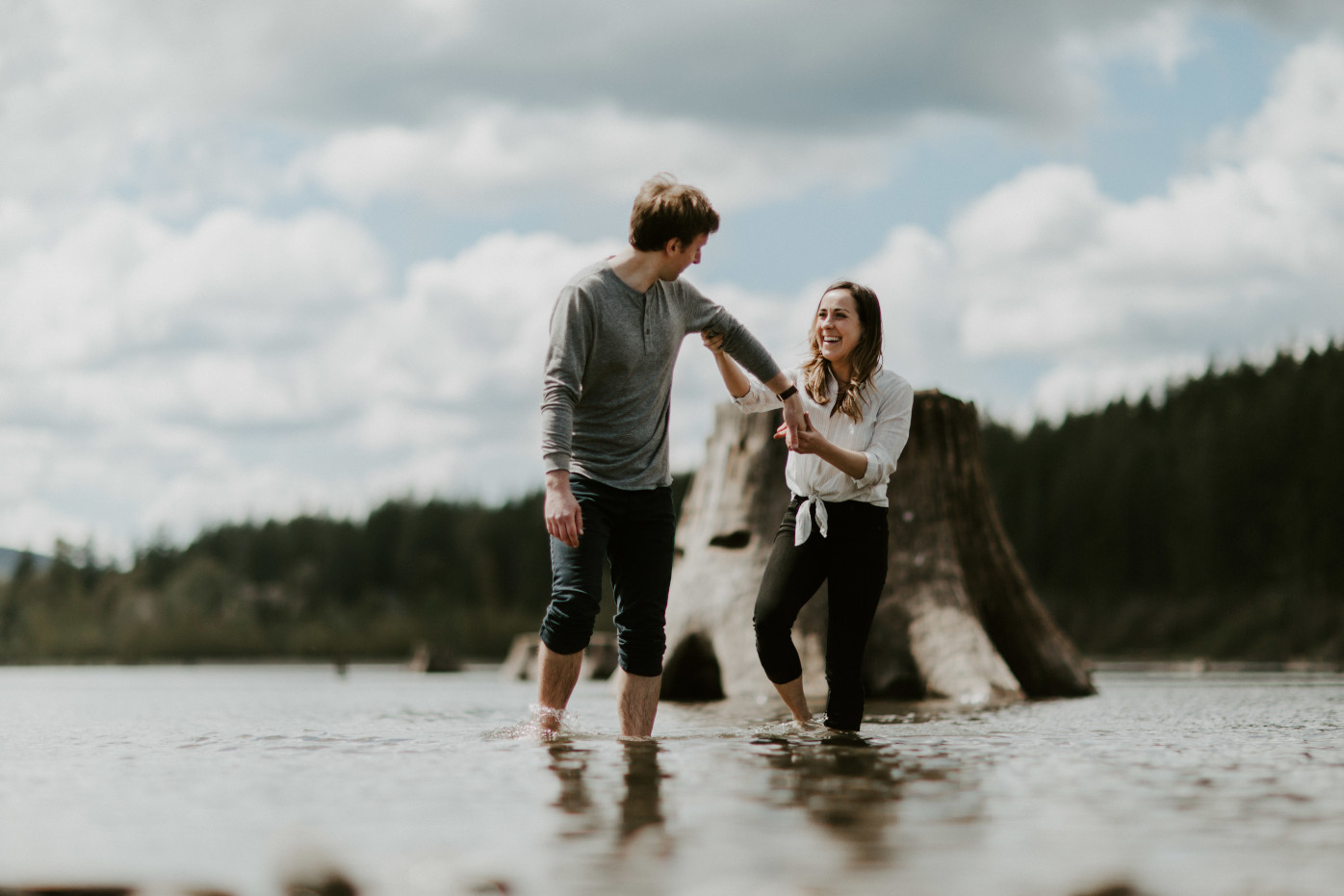 Adam and Janelle wade through the water. Adventure engagement session at Rattlesnake Lake, Washington by Sienna Plus Josh.