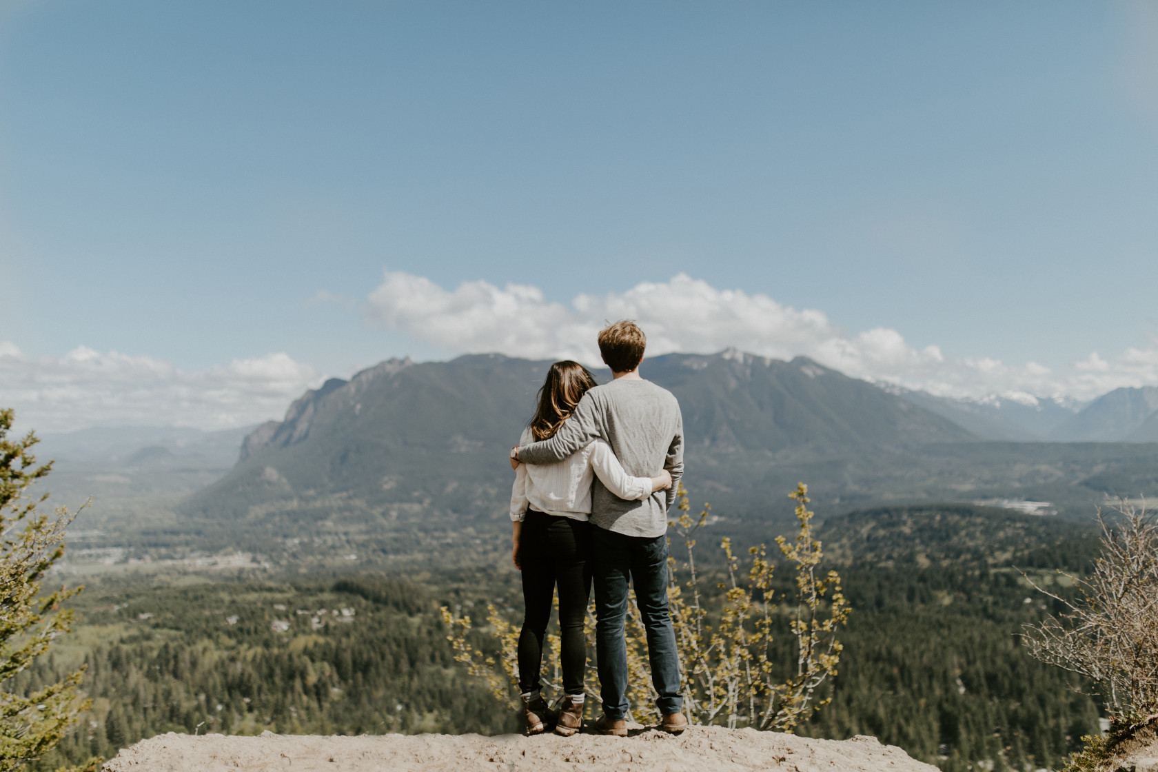 Janelle and Adam stand side by side at Rattlesnake Ledge. Adventure engagement session at Rattlesnake Lake, Washington by Sienna Plus Josh.