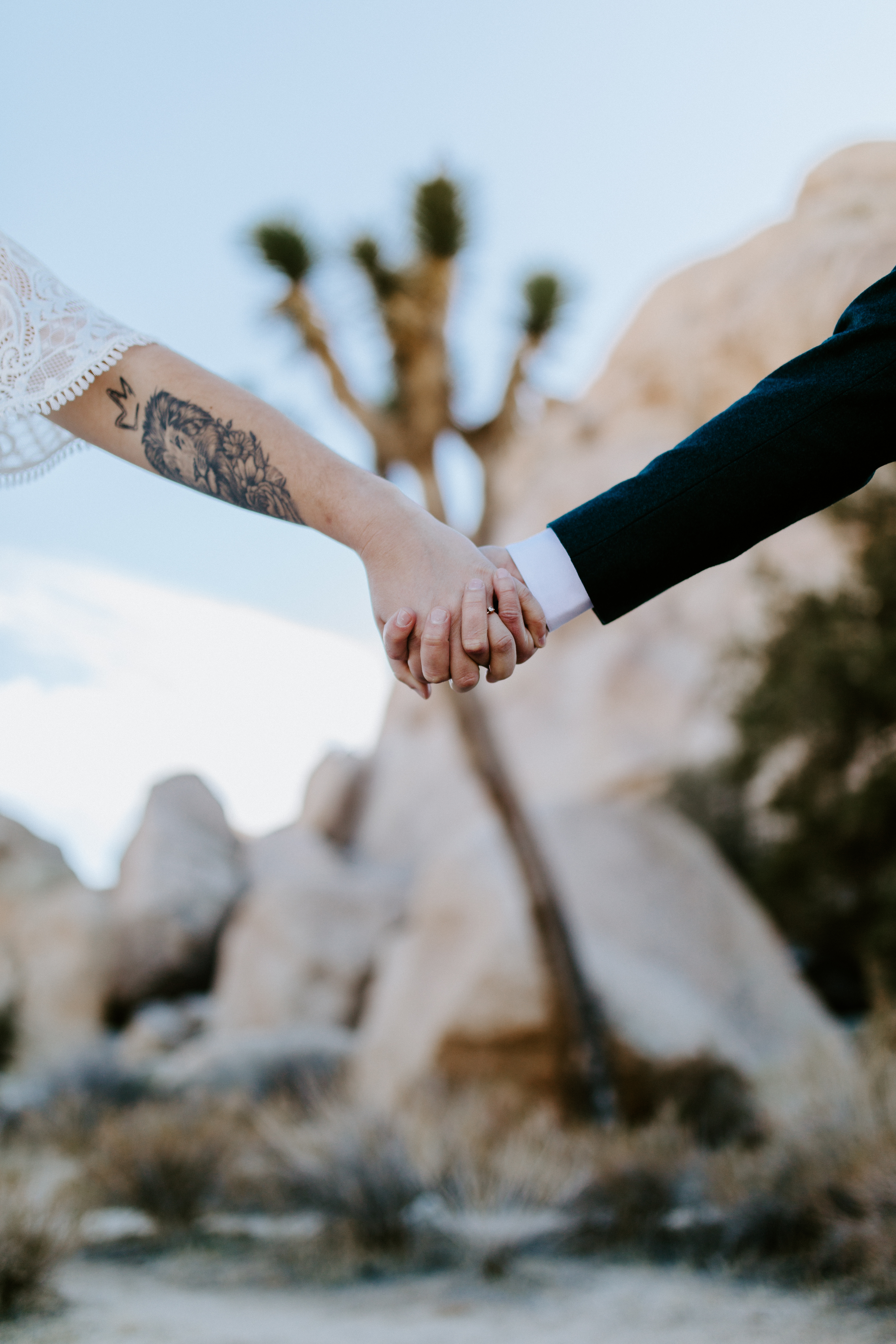 A bride and groom hold hands in Joshua Tree National Park after their elopement.