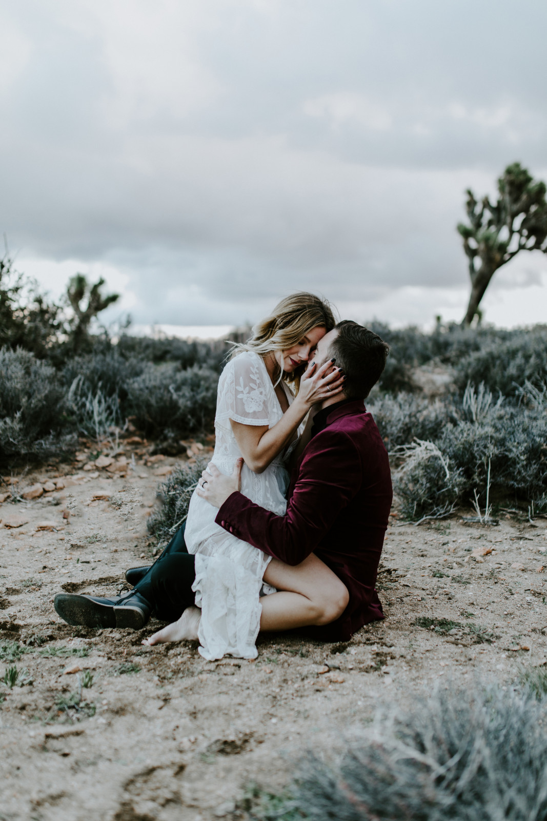 A couple sits together in the desert of Joshua Tree National Park after their elopement ceremony.