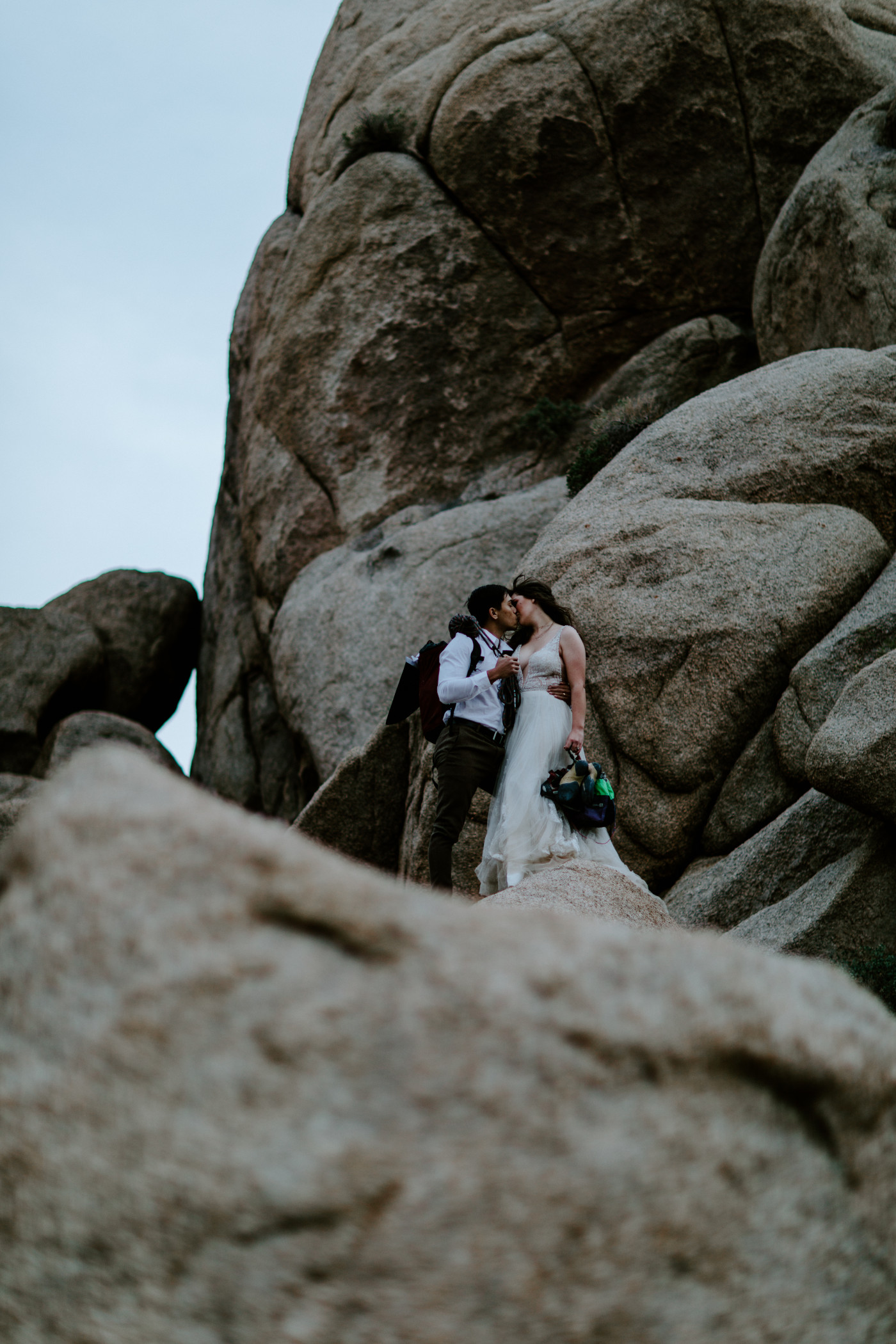 Zack and Shelby kiss on top of the rocks in Joshua Tree.