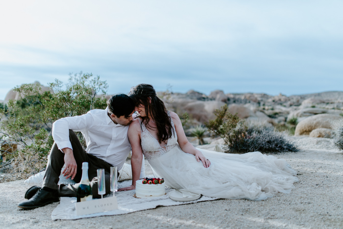 Shelby and Zack have a picnic in Joshua Tree on a boulder.